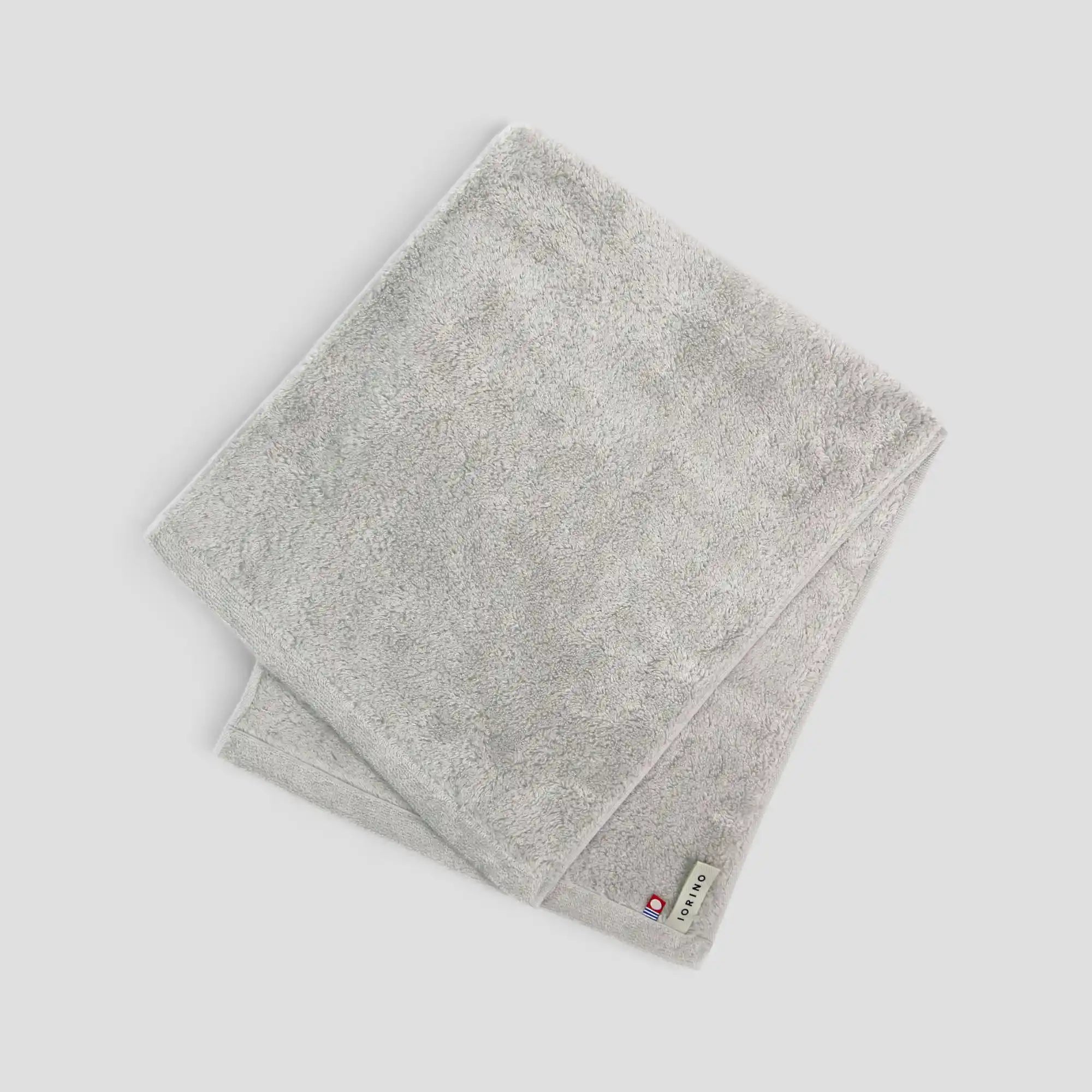 Gray Imabari towel with a brand label on a light gray background
