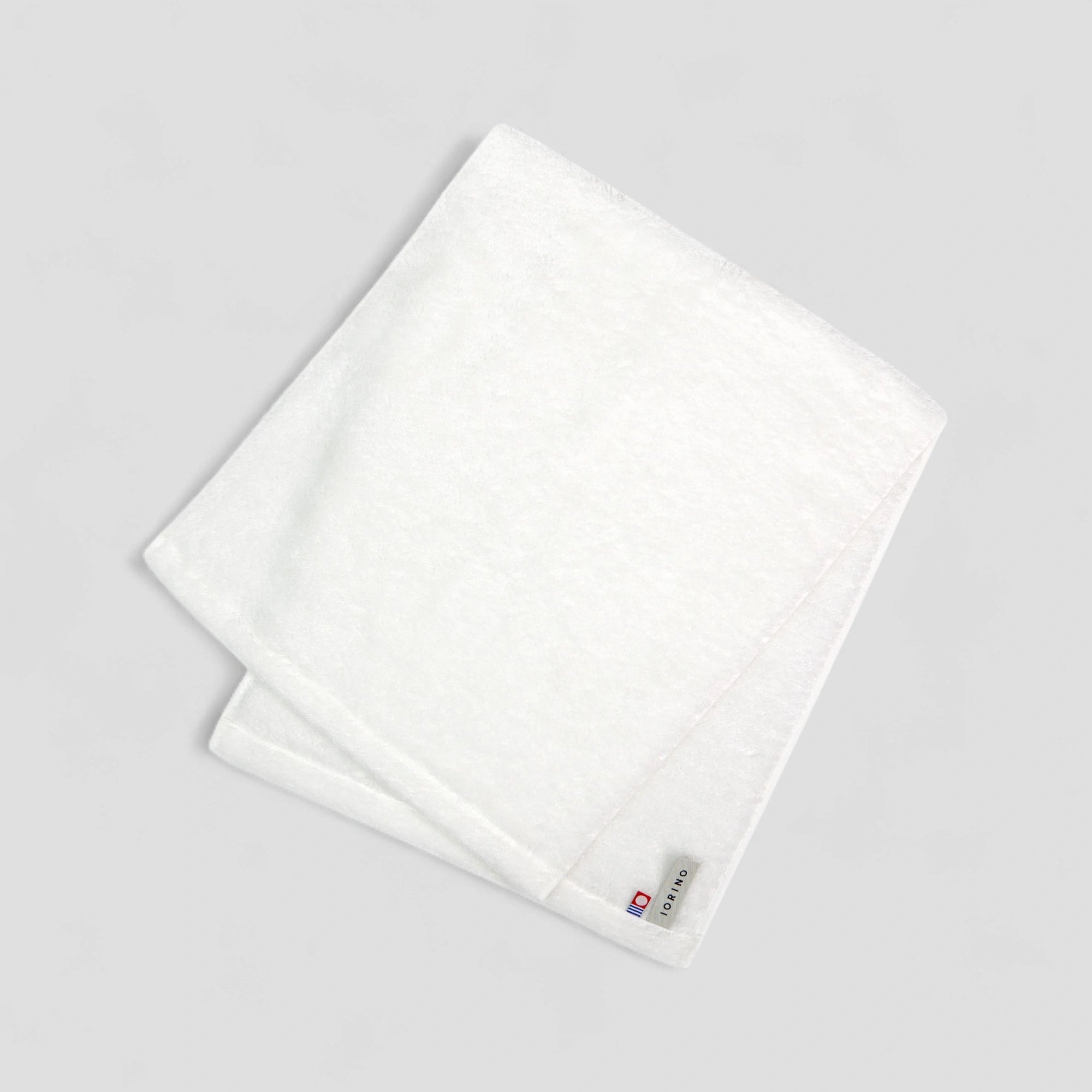 White Imabari towels with a brand logo on a light gray background