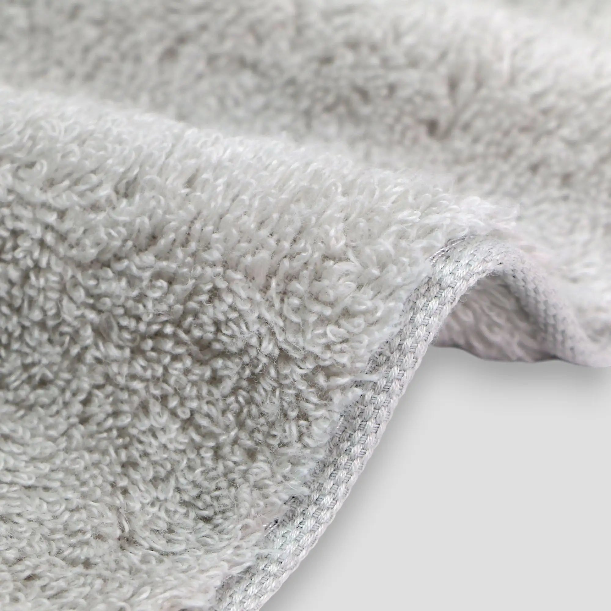 Close-up of textured gray Imabari towel fabric on a white background