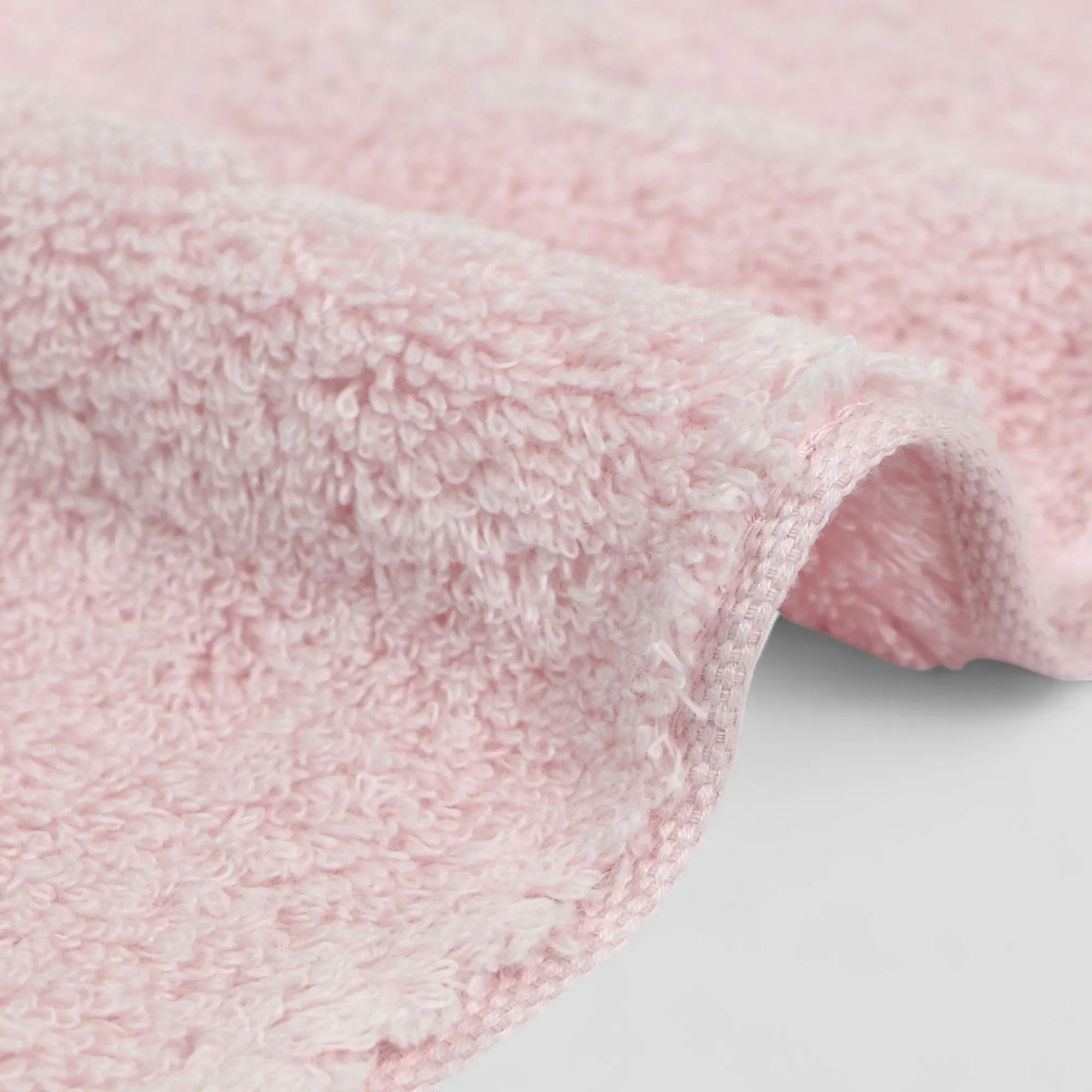Close-up of pink Imabari towel textured fabric on a light gray background