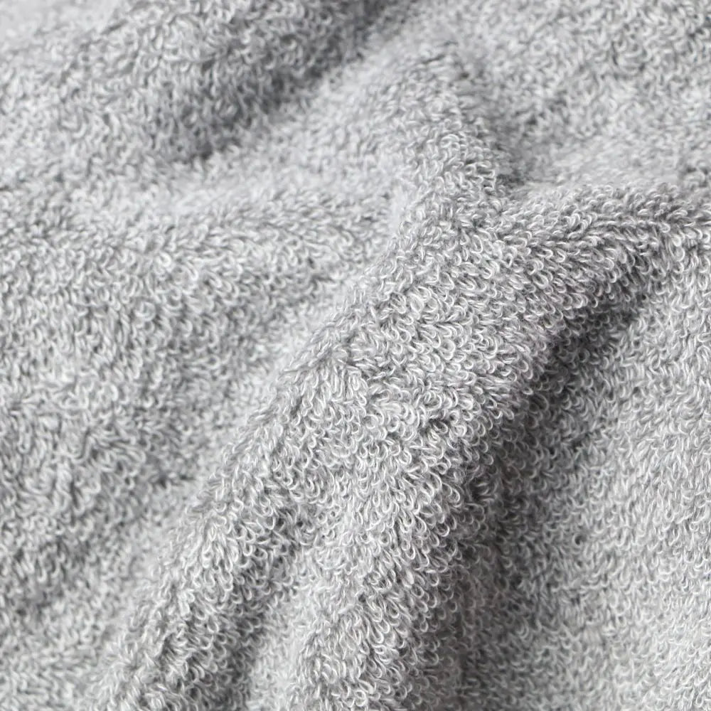 Close-up of a light gray textured fabric Imabari towel bathrobe, showing the detailed loop pile of a terry cloth or fleece material.