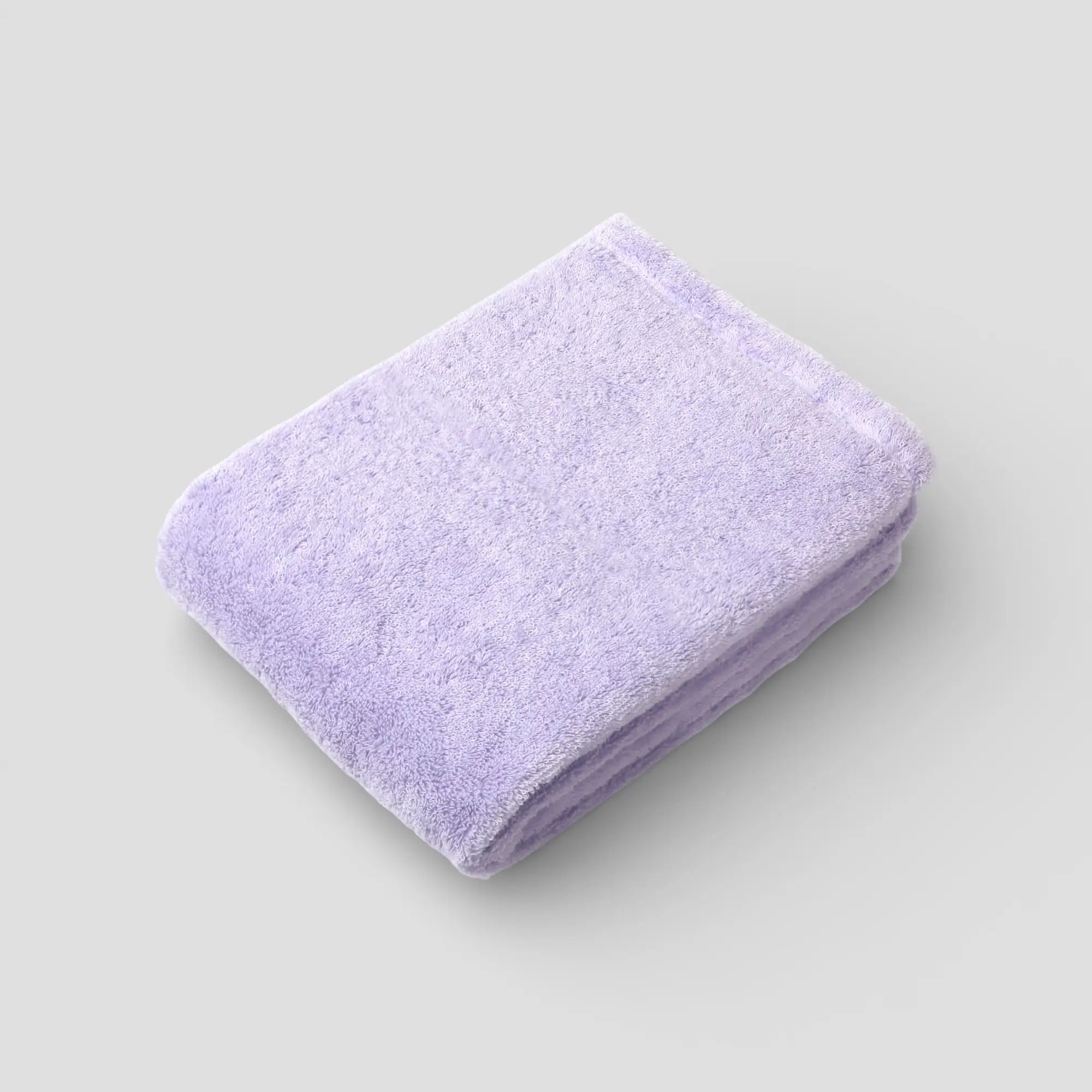Folded purple Imabari towel on a light gray background
