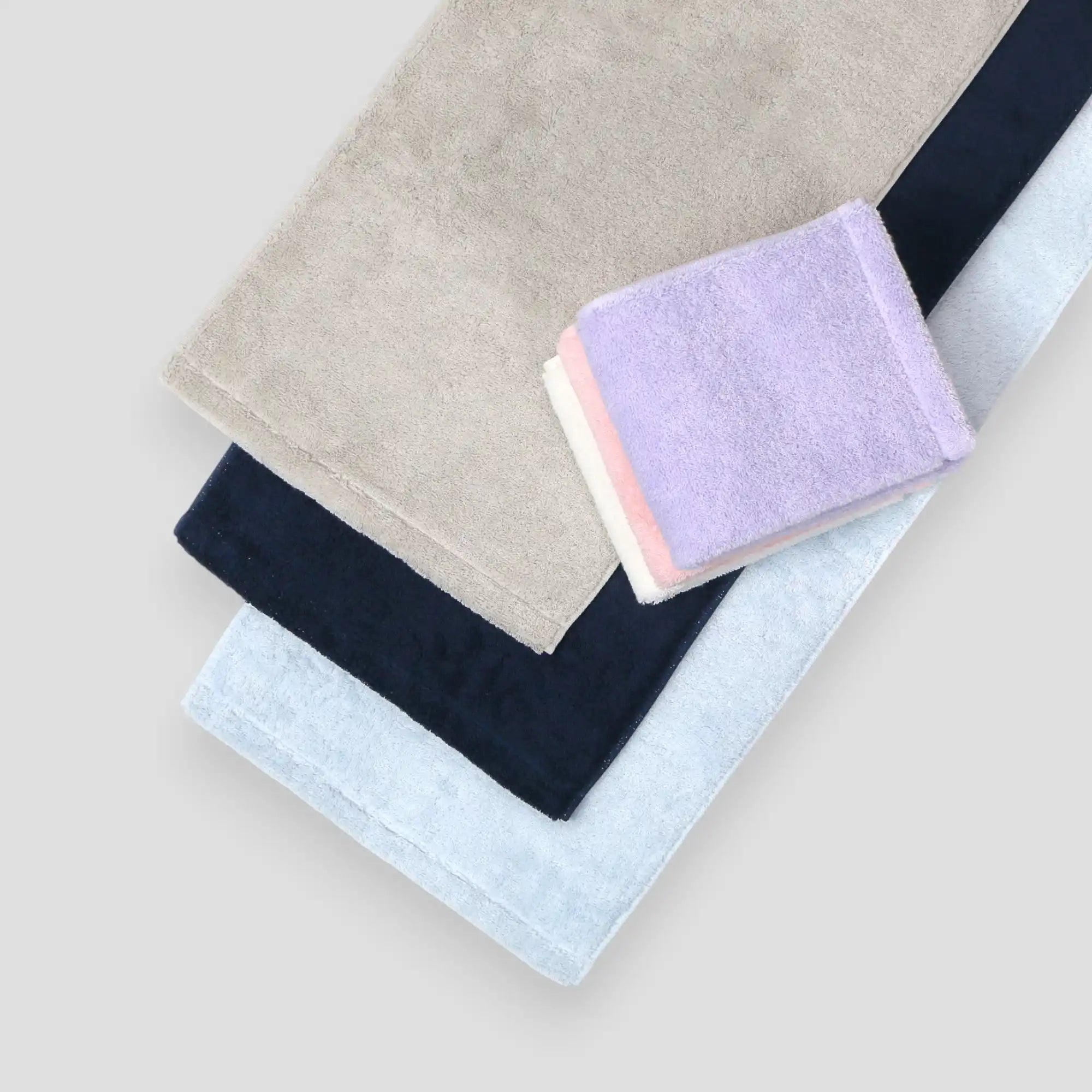 Set of folded Imabari towels in various colors on a light background