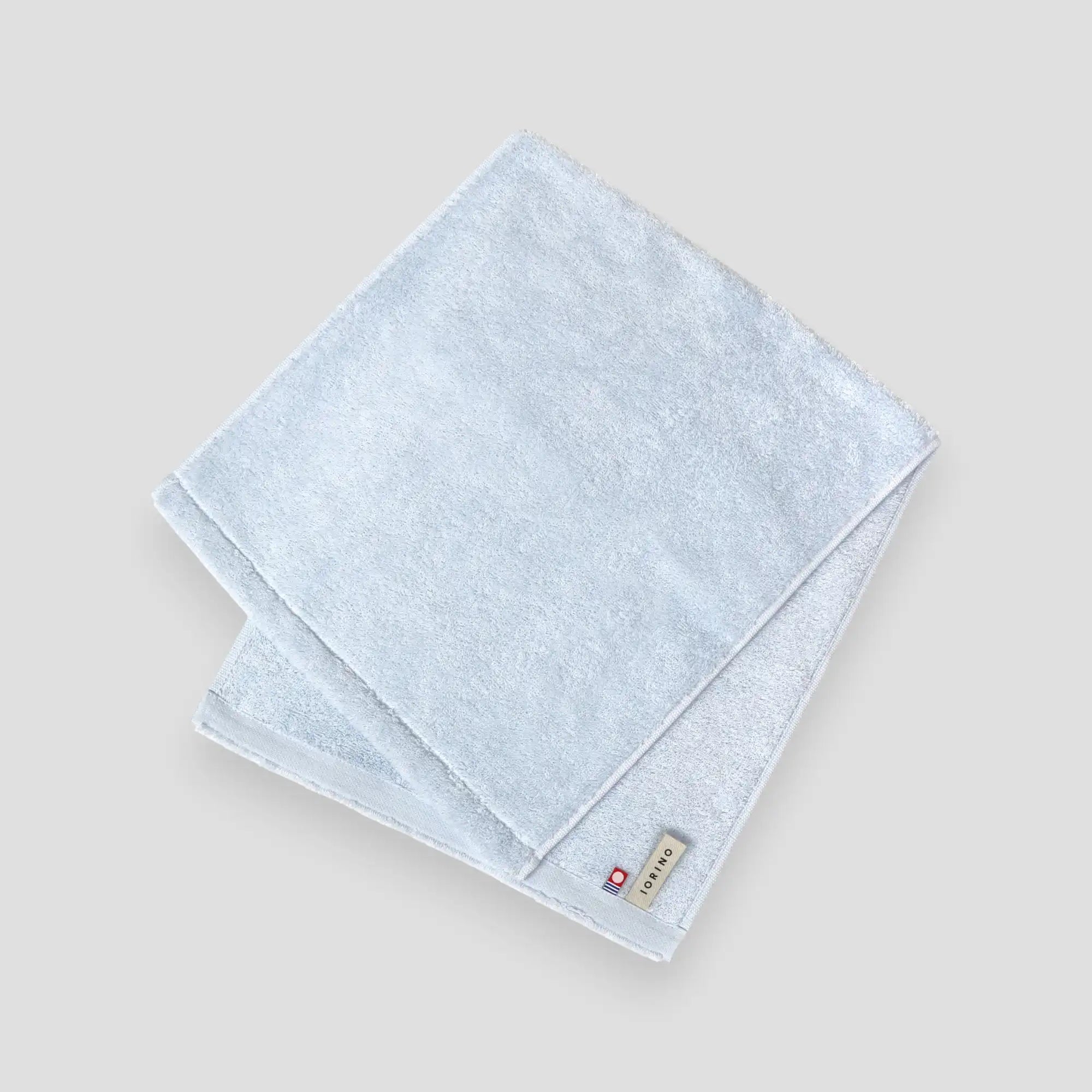 Light blue folded Imabari towel on a gray background