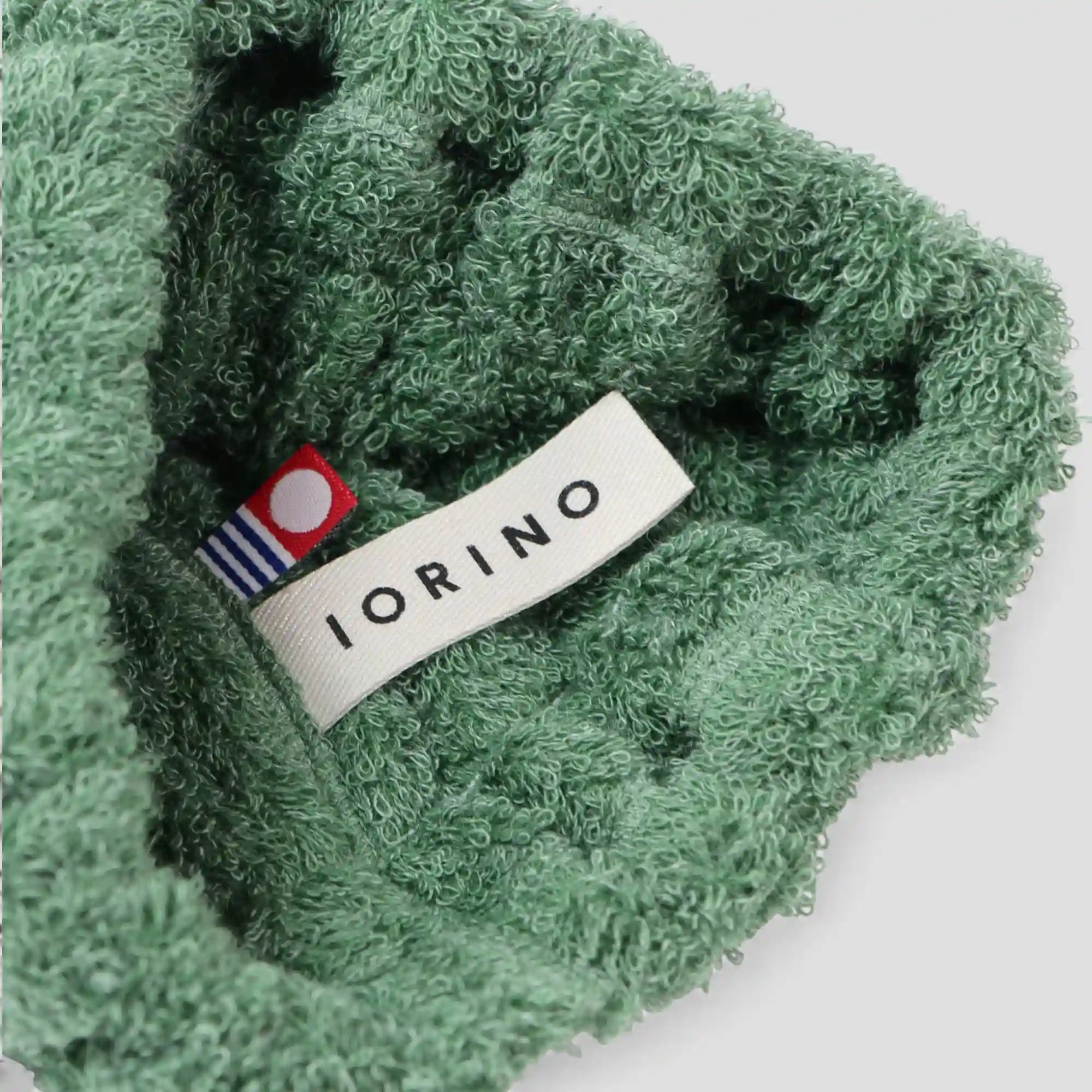 Green textured Imabari towel with a visible brand label on a white background