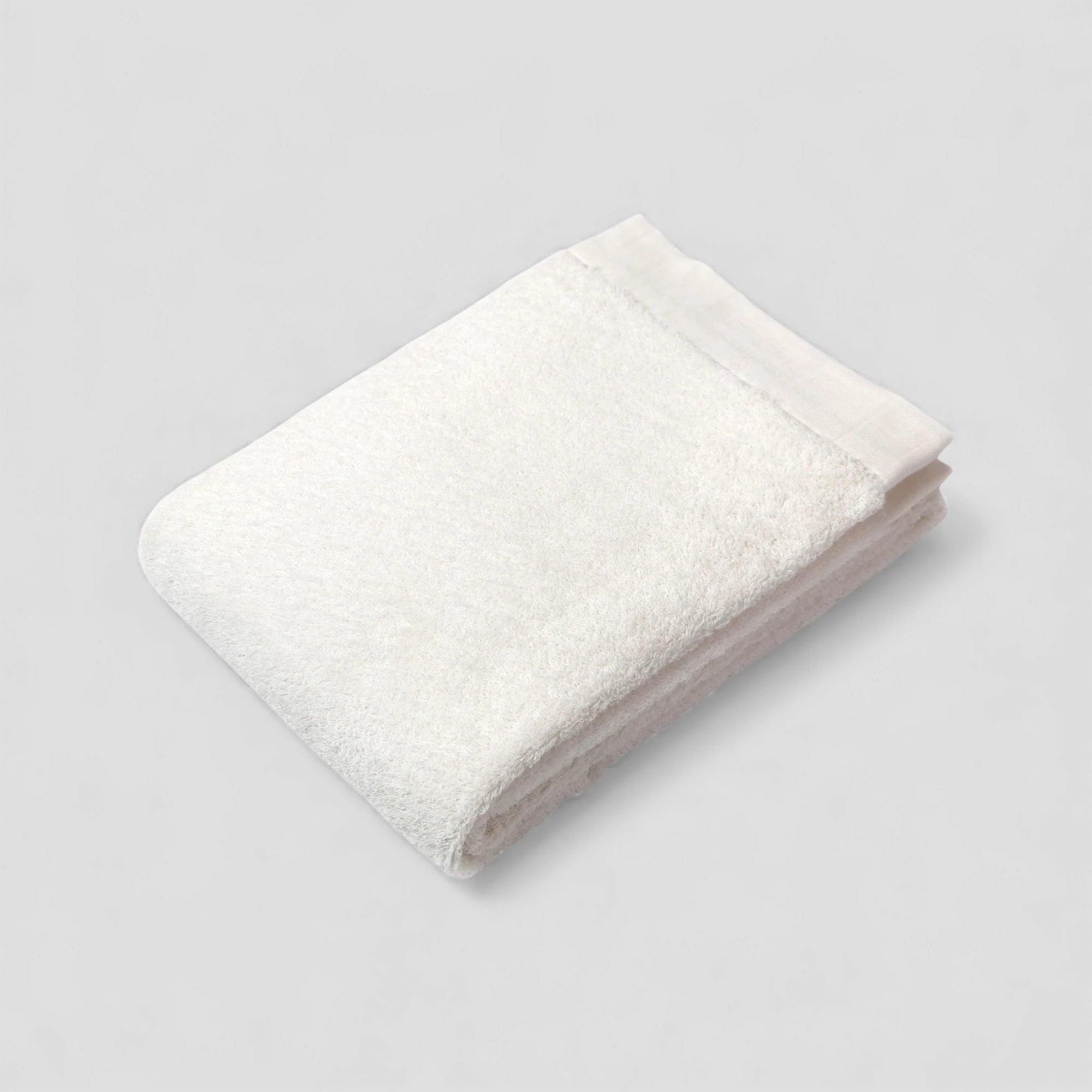 Folded white Imabari towel on a light gray background