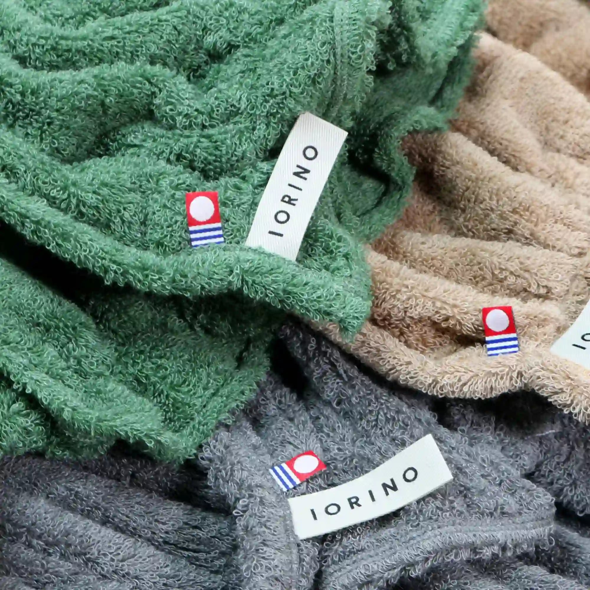 Stack of green, beige, and gray Imabari towels with &