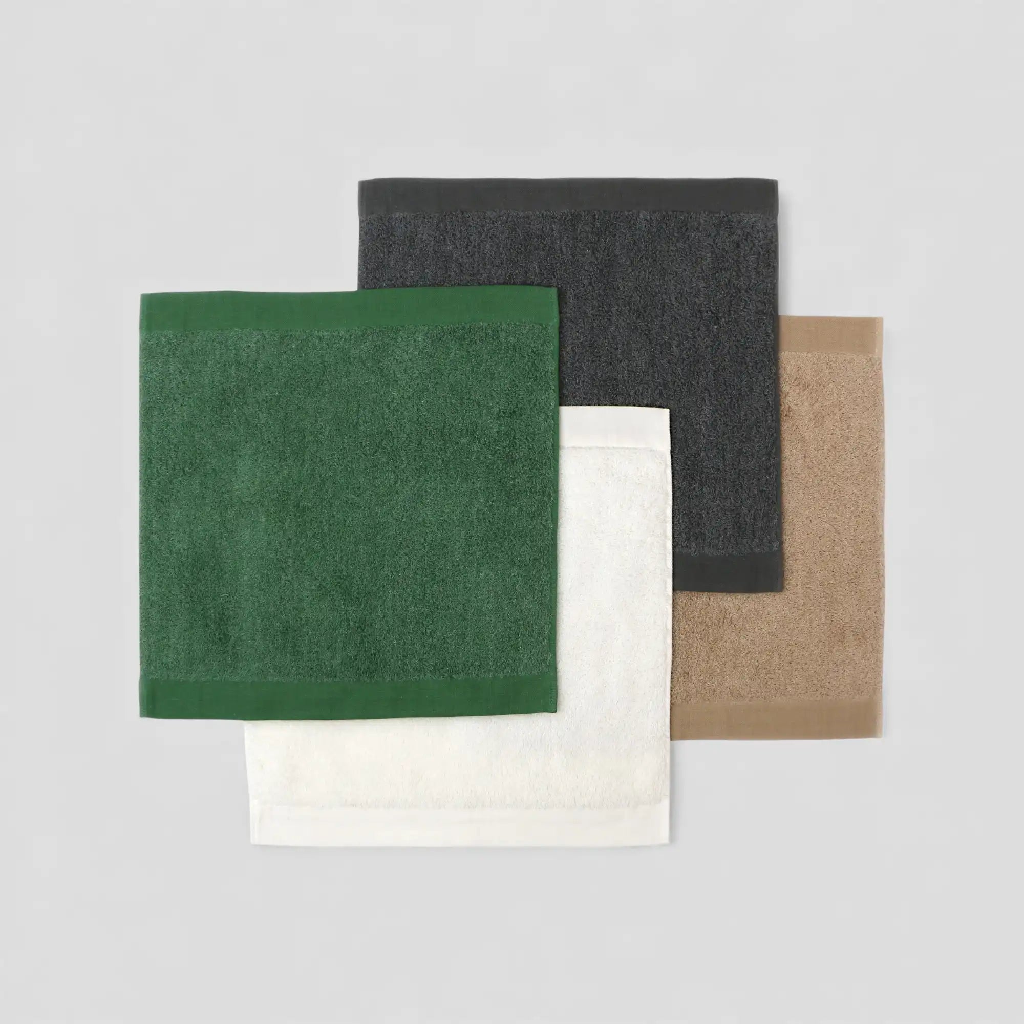 Four square Imabari towel in green, black, white, and beige on a light gray background