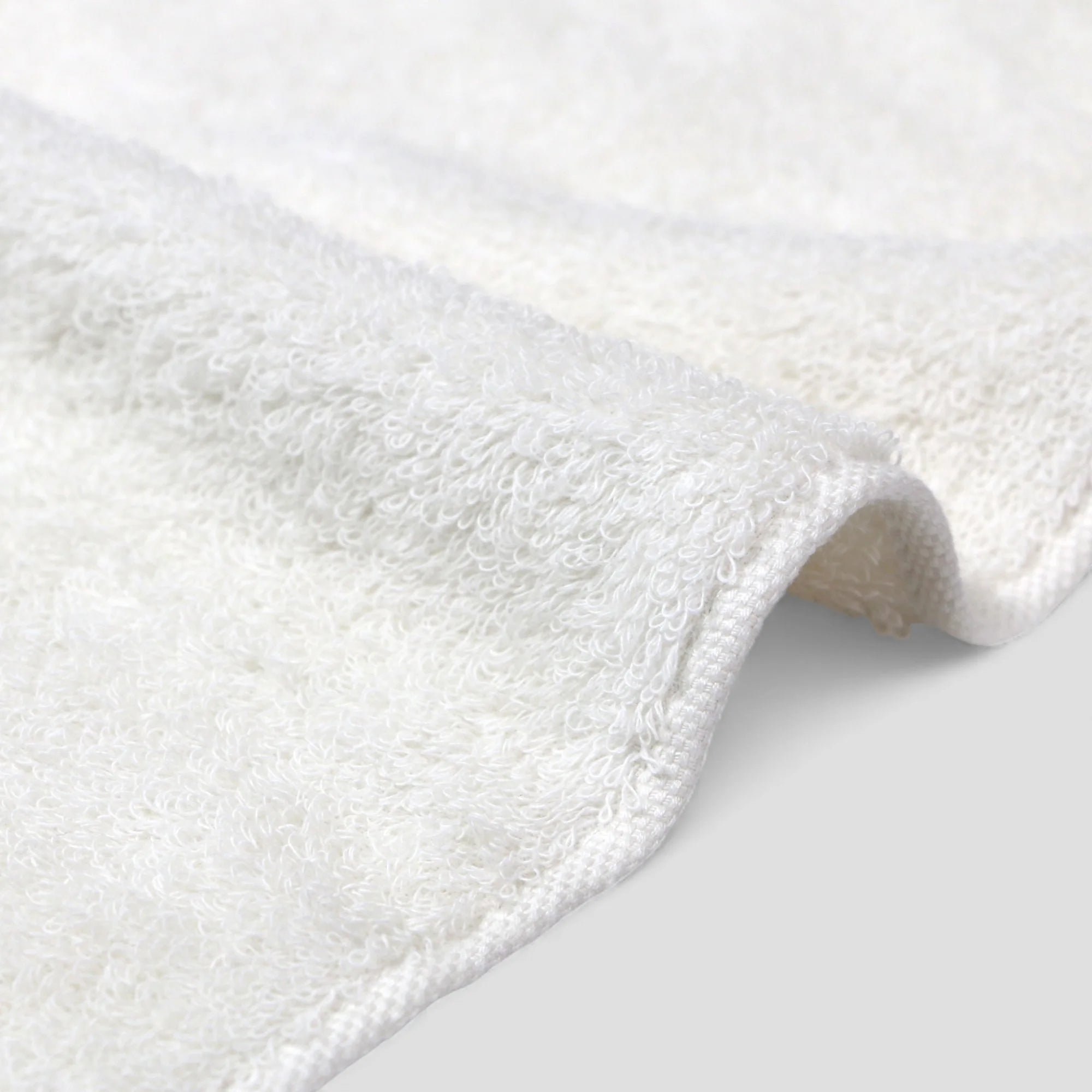 Close-up of a white Imabari towel on a light gray background