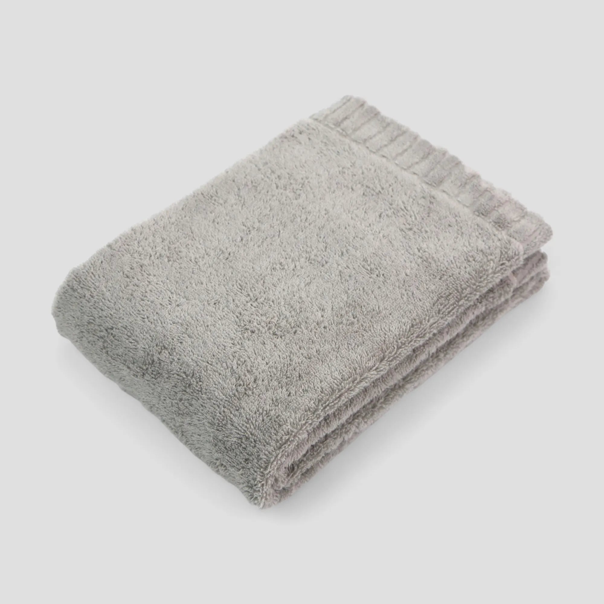 Folded gray Imabari towel on a light gray background