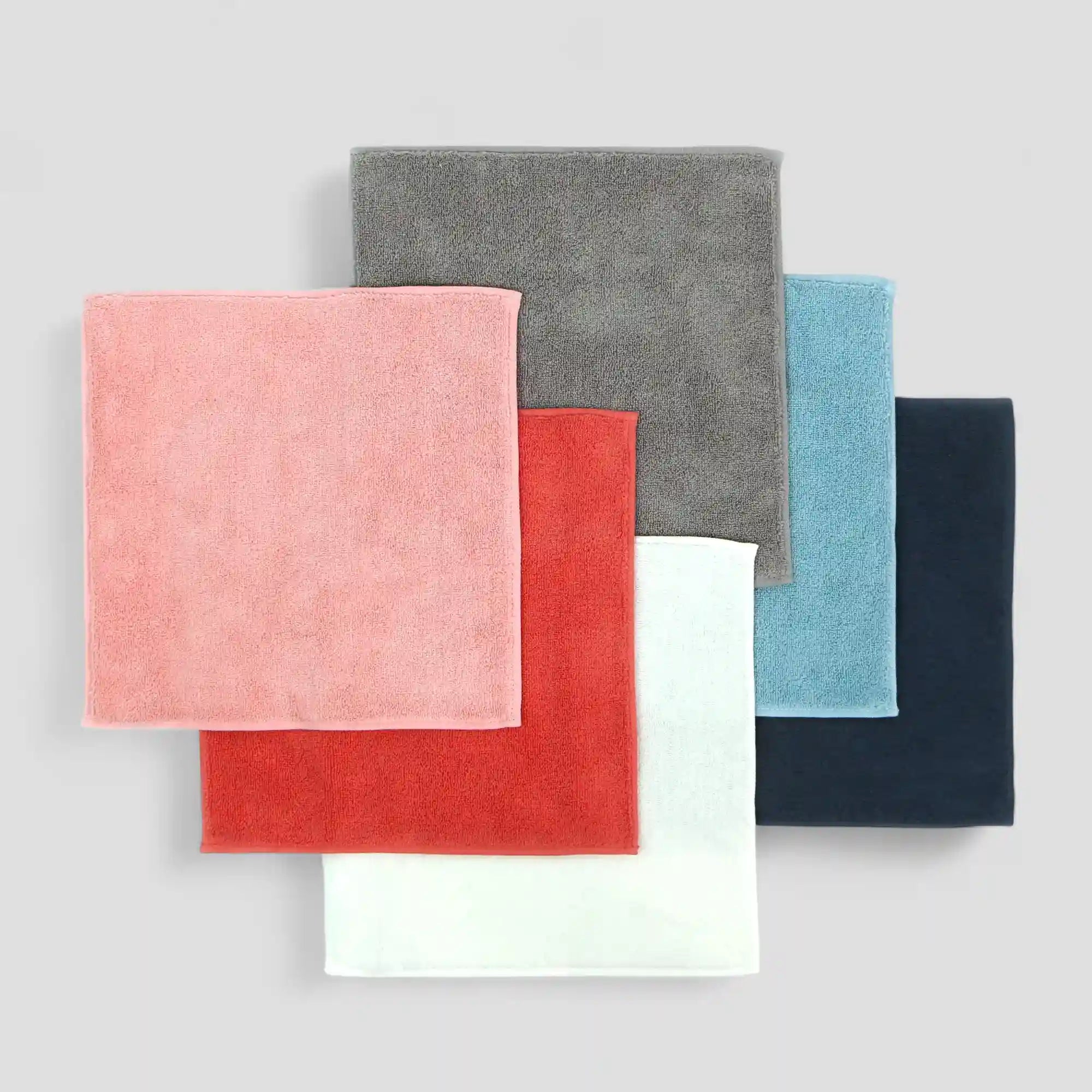 Set of six colorful Imabari towels stacked on a light gray background