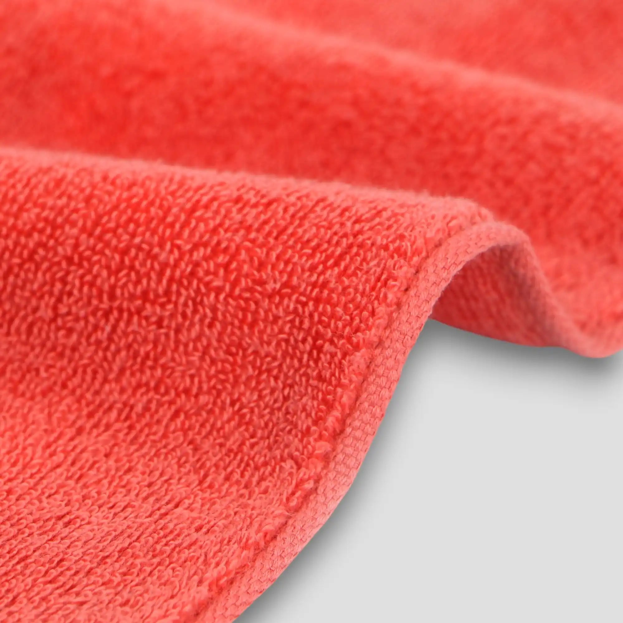 Close-up of a red Imabari towel with a textured surface on a light gray background