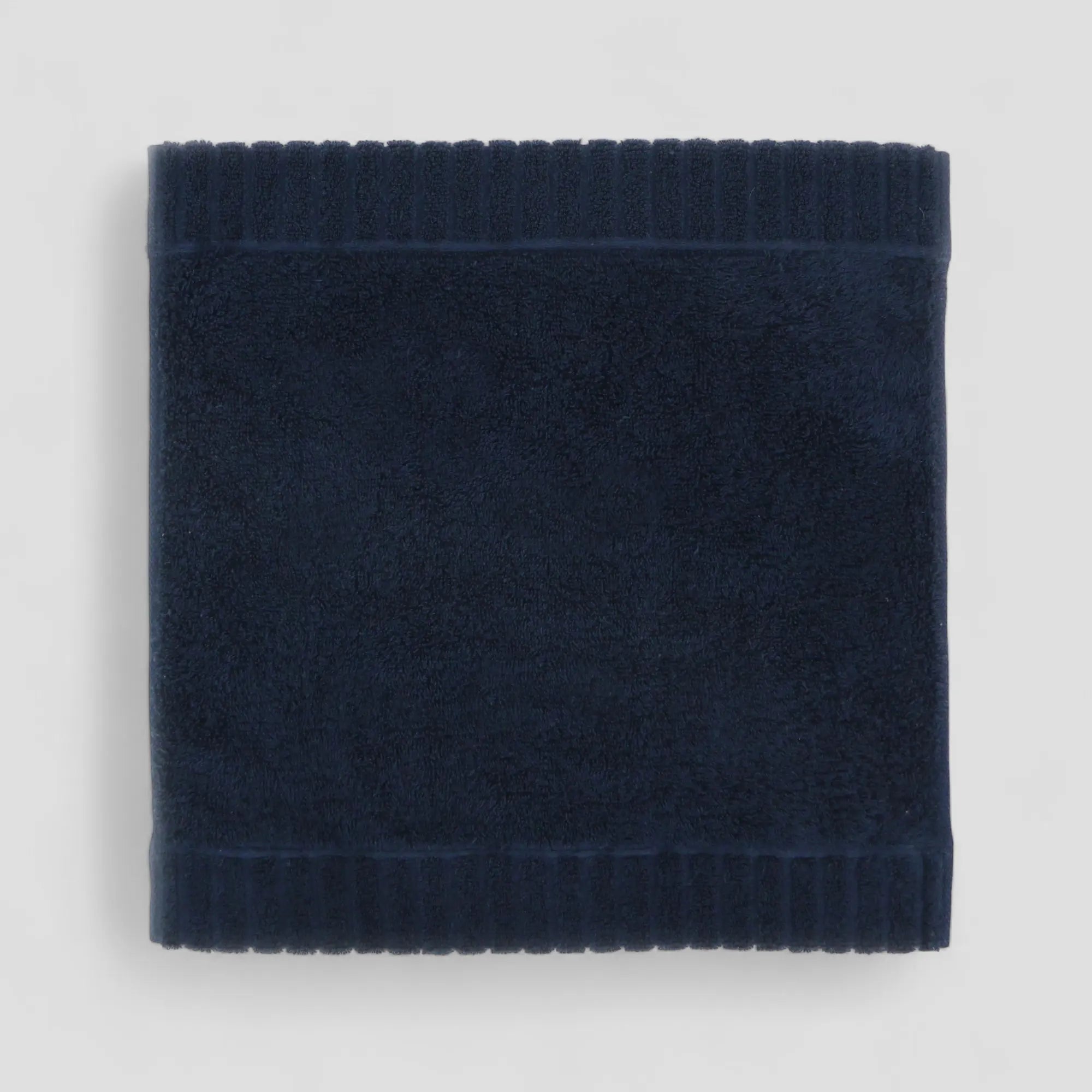 Navy blue Imabari towel on a light gray background