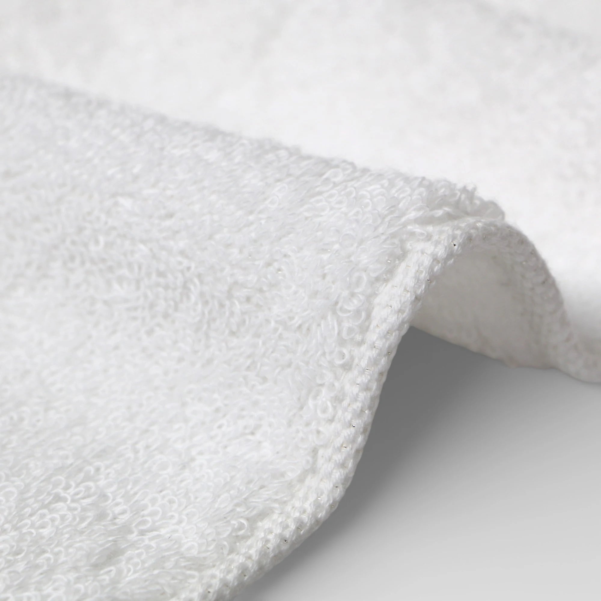 Close-up of a white Imabari towel textured fabric on a light gray background