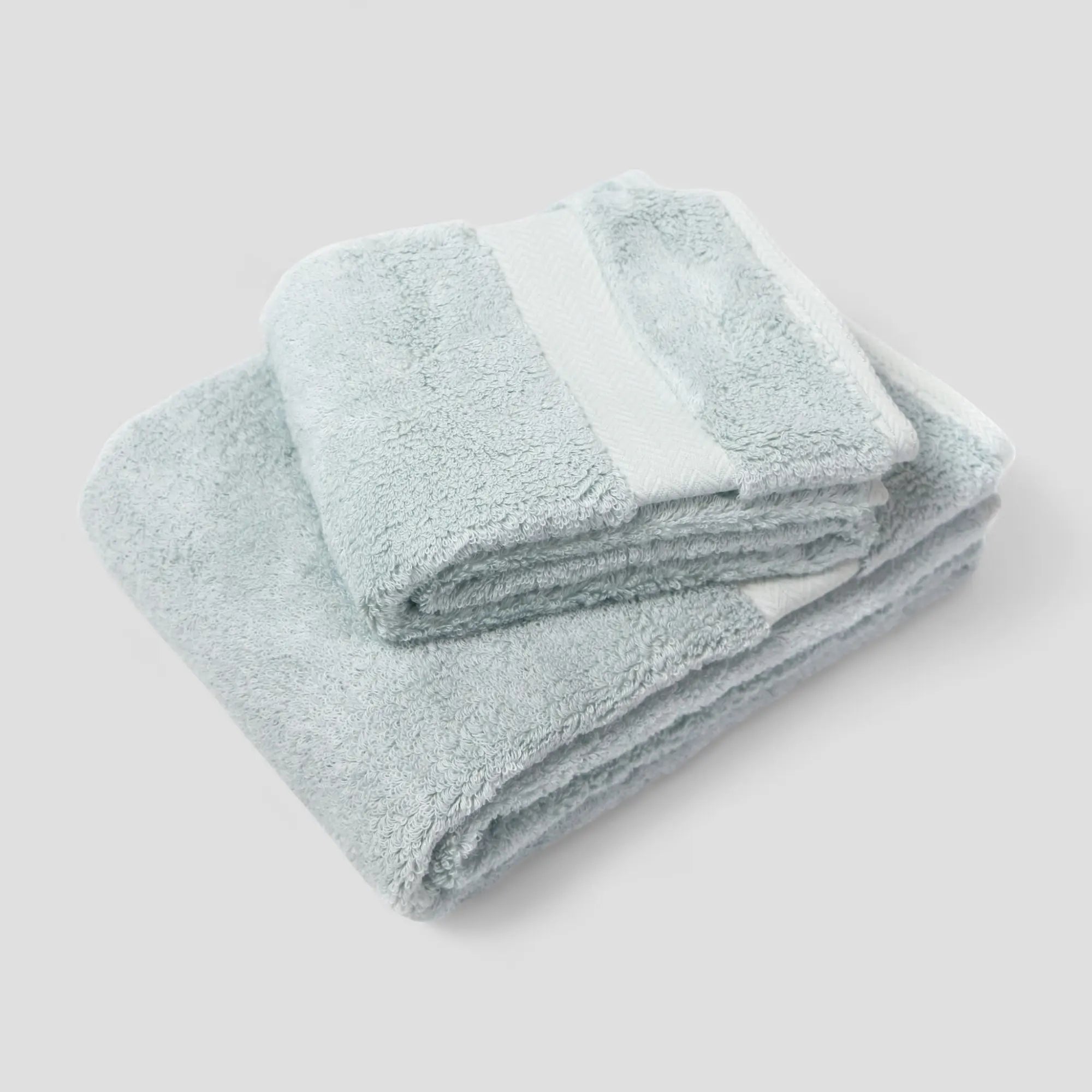 Folded light blue Imabari towels on a white background