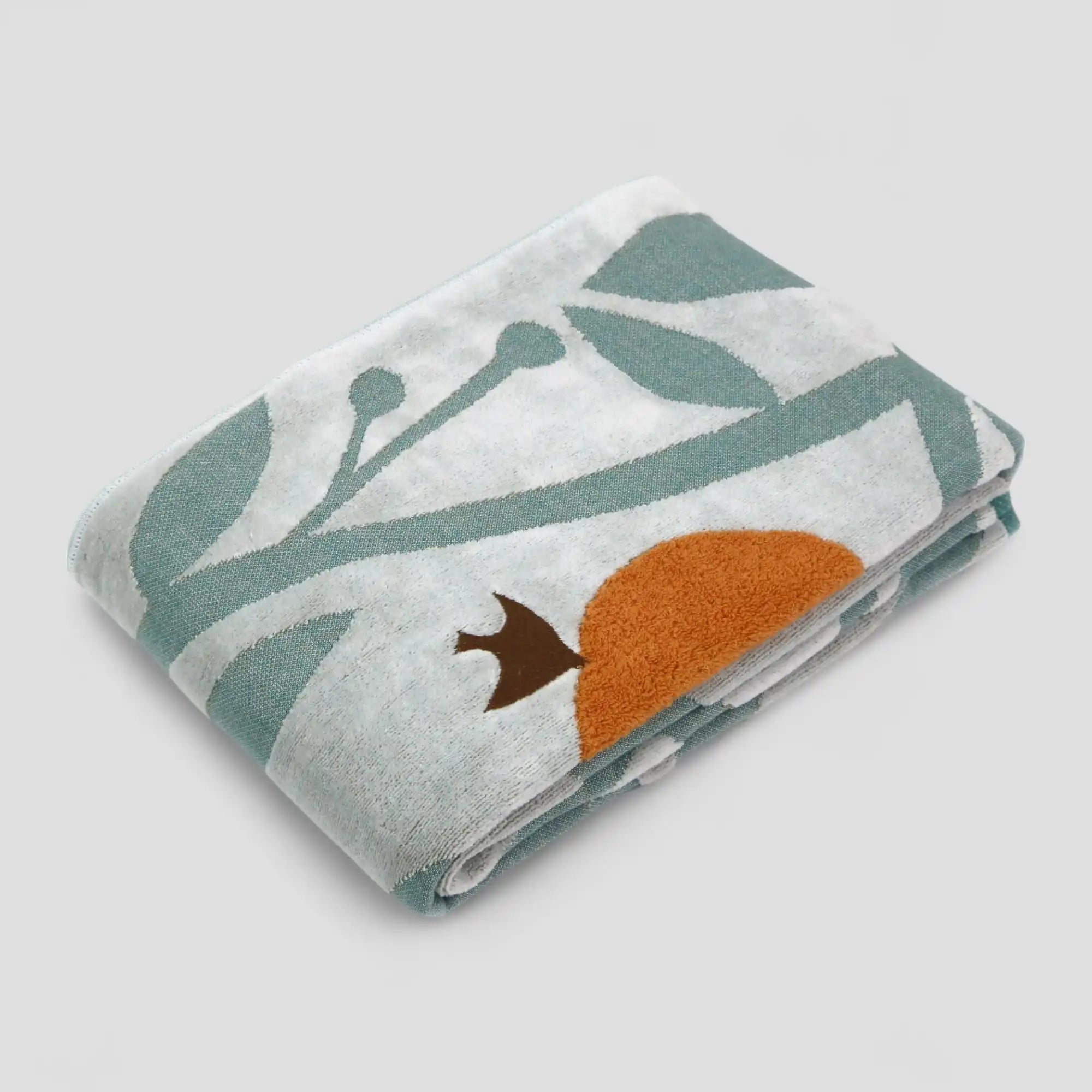 A folded Imabari towel with a bird, orange and leaf pattern in the white background.