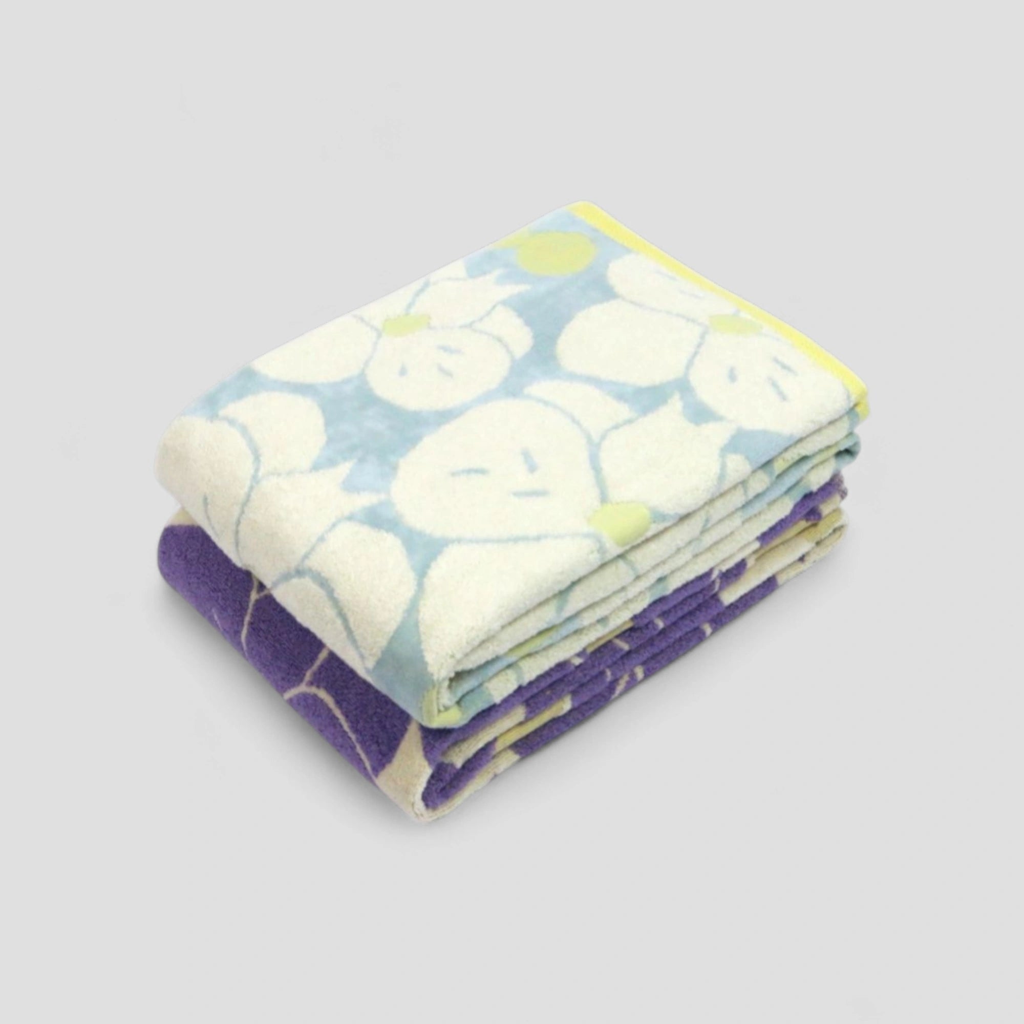 Stack of folded Imabari towel with floral pattern on a light gray background