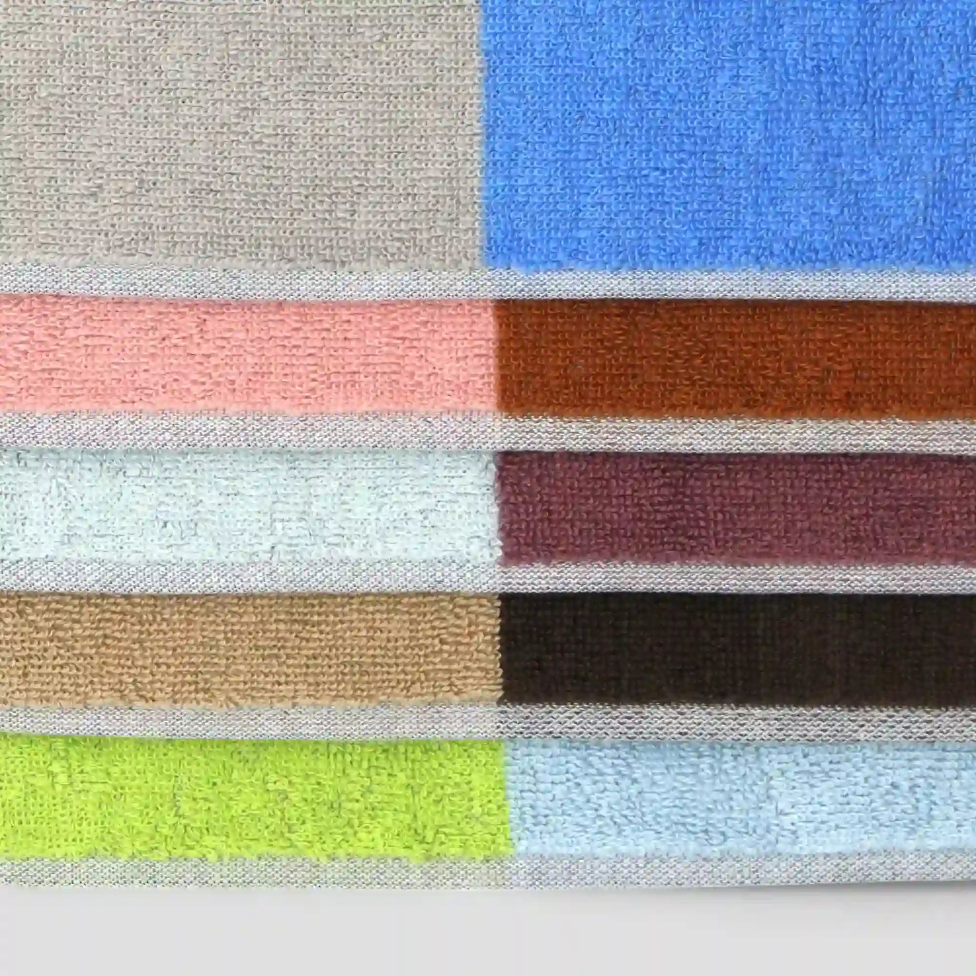 A collection of Imabari towels in various colors, including beige, brown, gray, pink, purple, blue, and green, displayed on a white background
