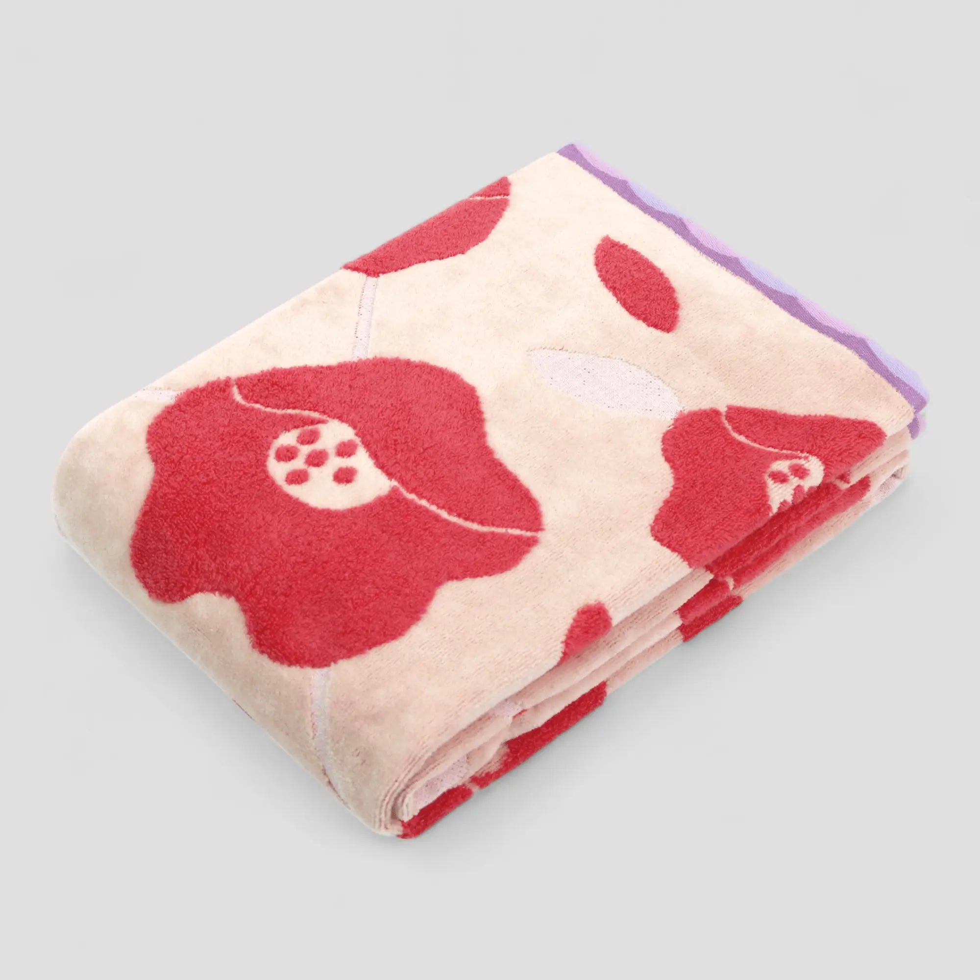 Folded Imabari towel with red floral pattern on a light gray background