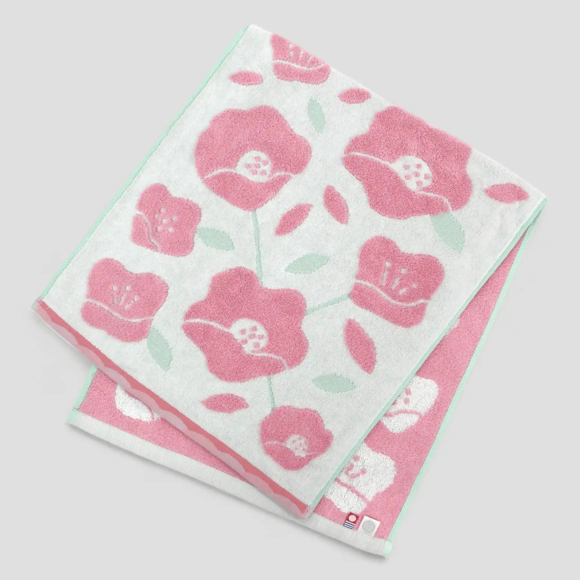 Floral patterned Imabari towel with pink flowers on a light-gray background
