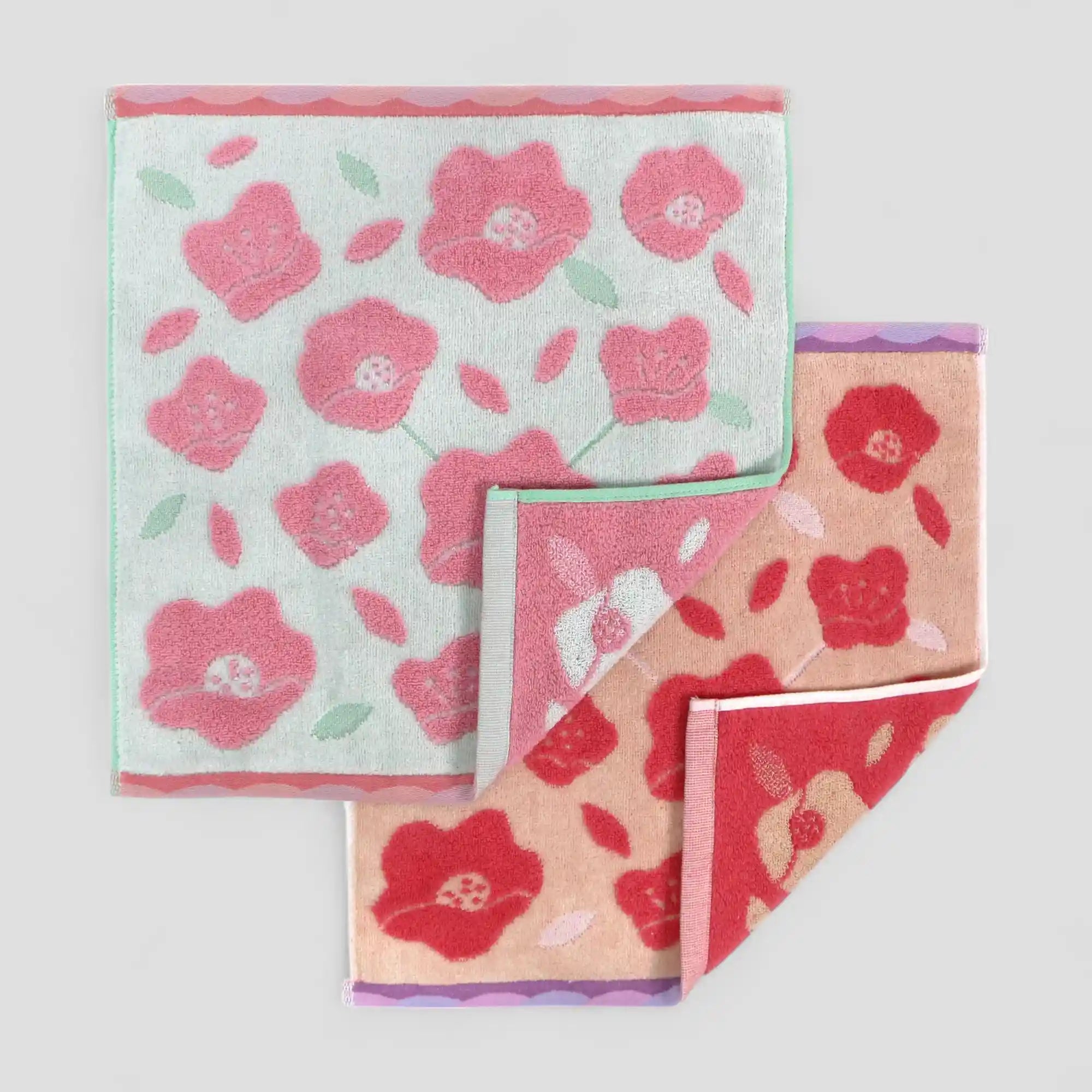 Two floral Imabari towels with pink and red flowers on a light gray background