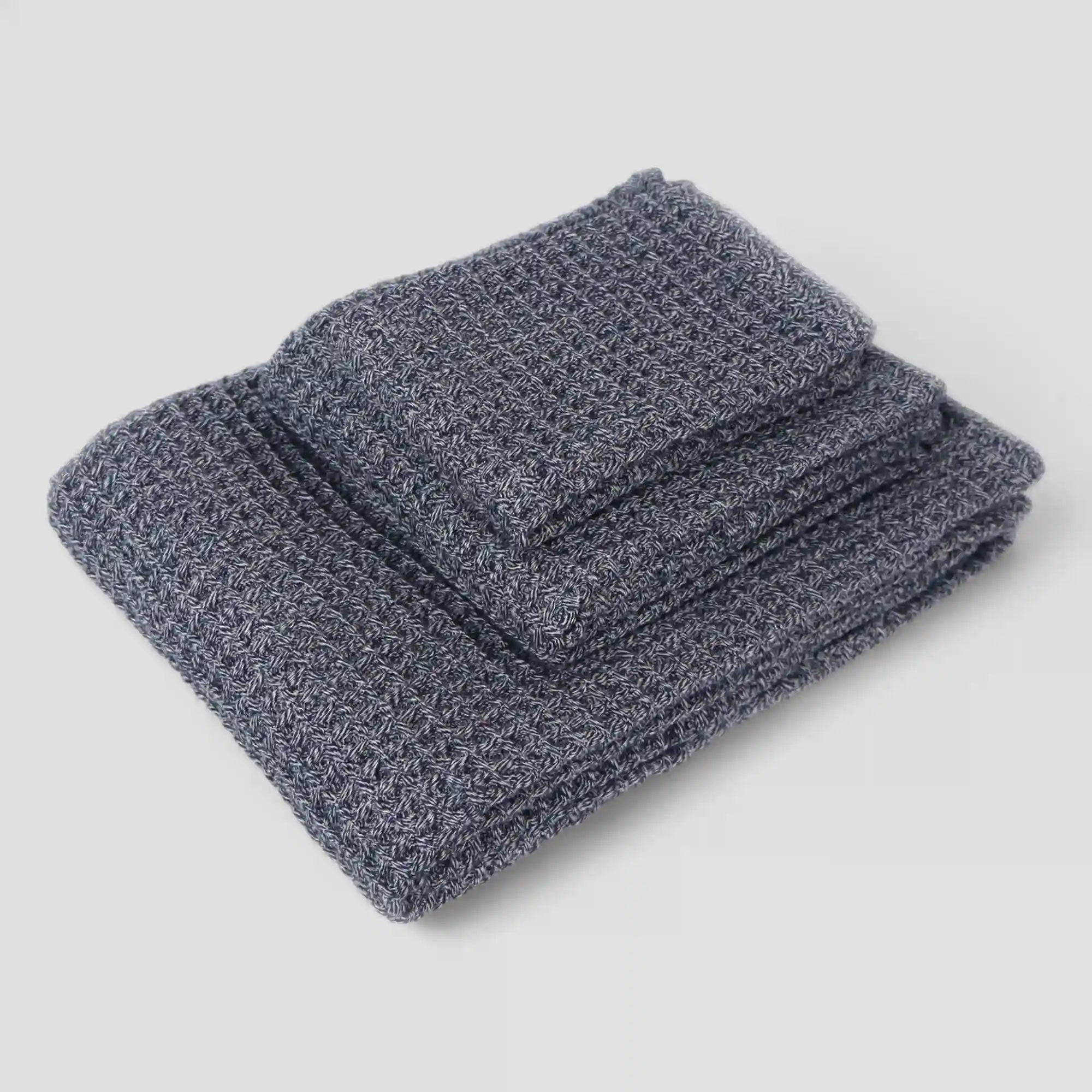 Folded 3 sets of navy blue waffle towel on a light gray background
