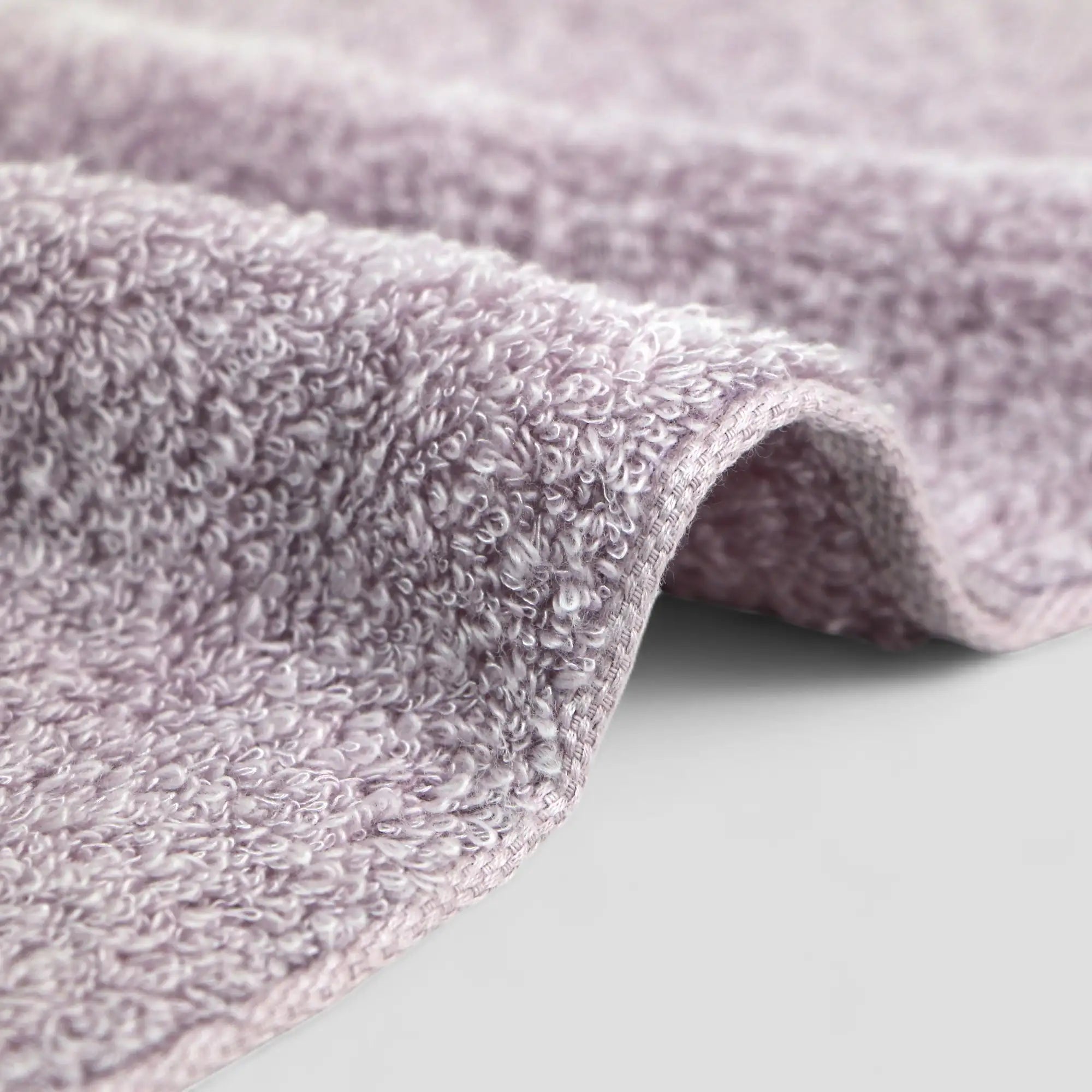 Close-up of a textured purple Imabari towel fabric on a light gray background