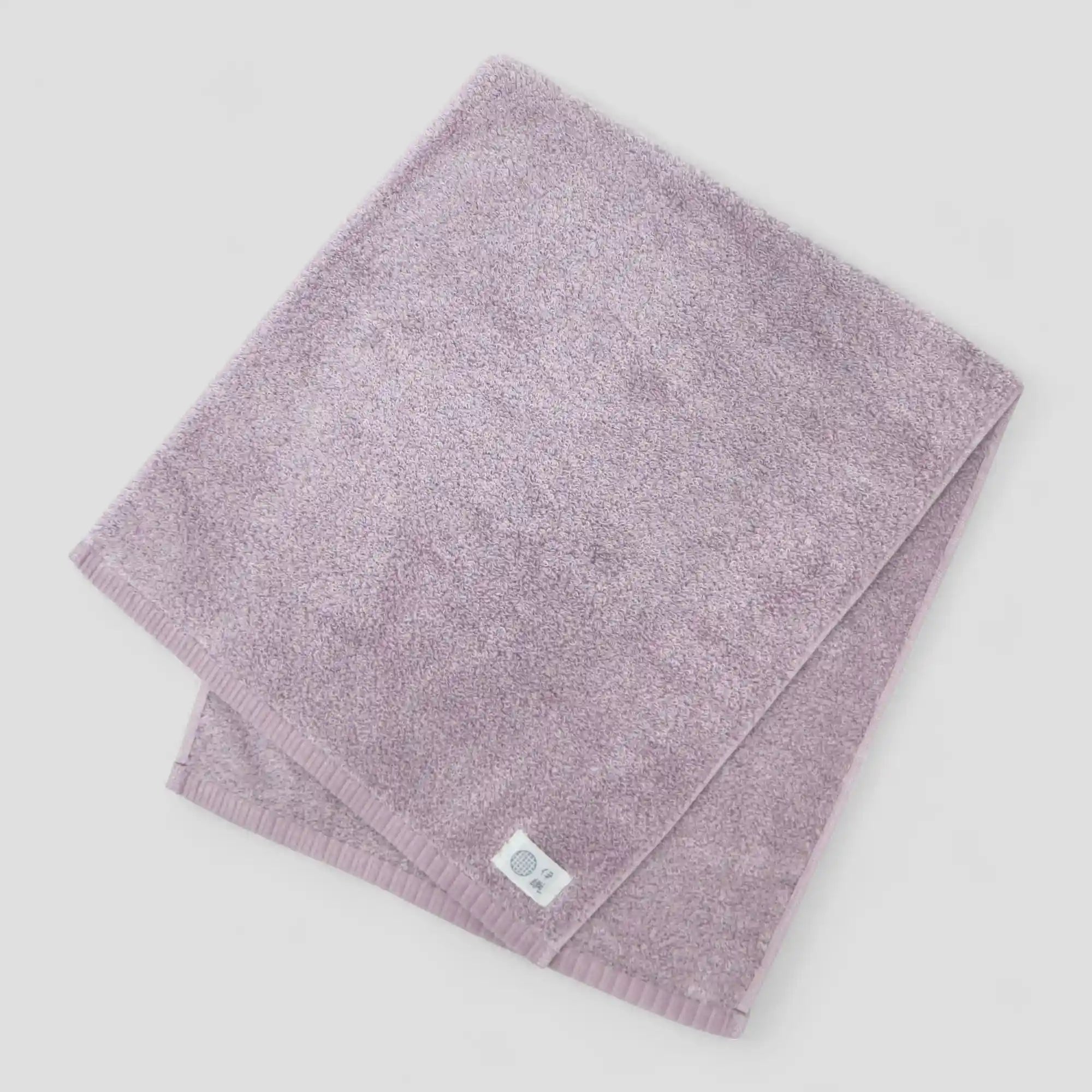 Folded purple Imabari towel on a light gray background