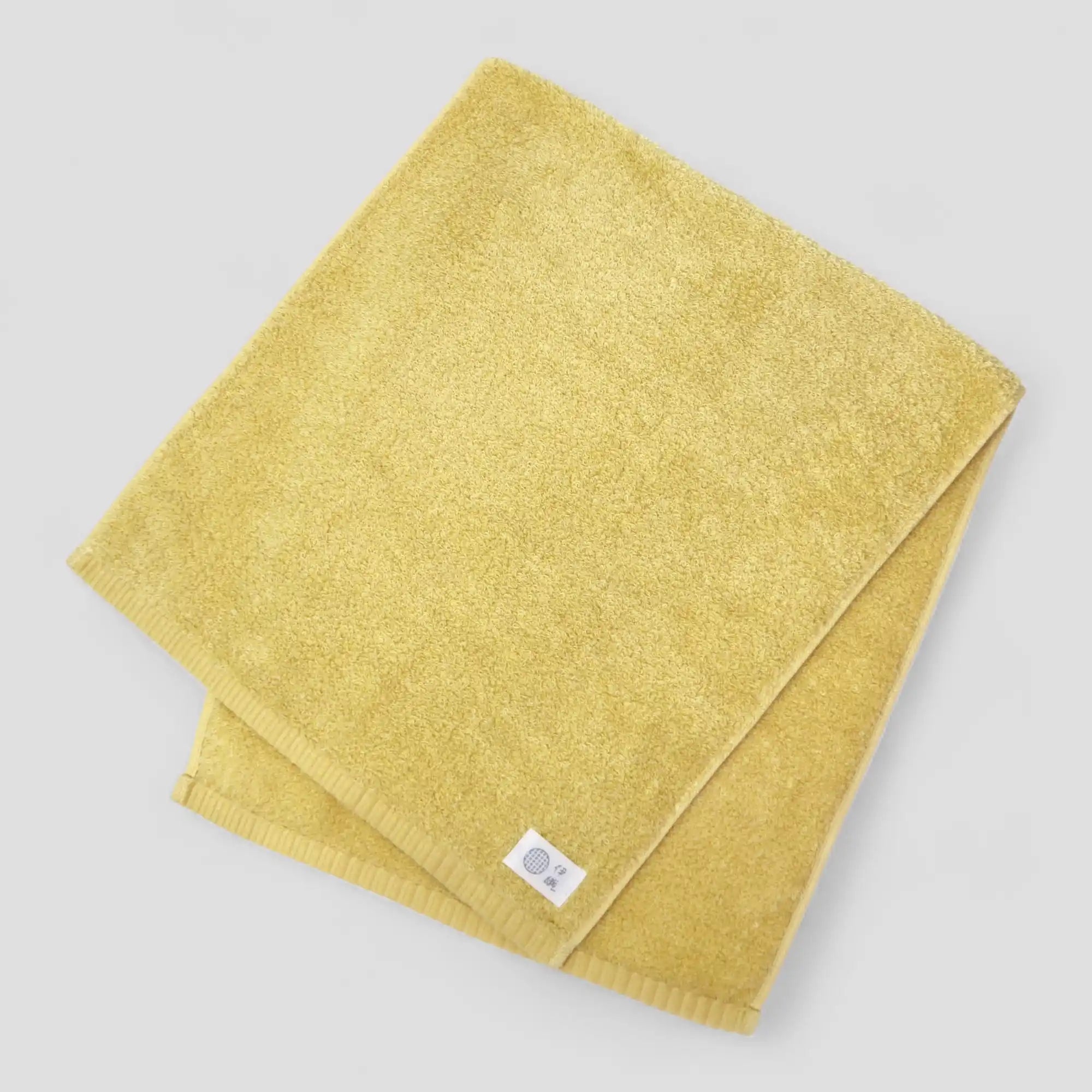 Yellow Imabari towel folded on a light gray background