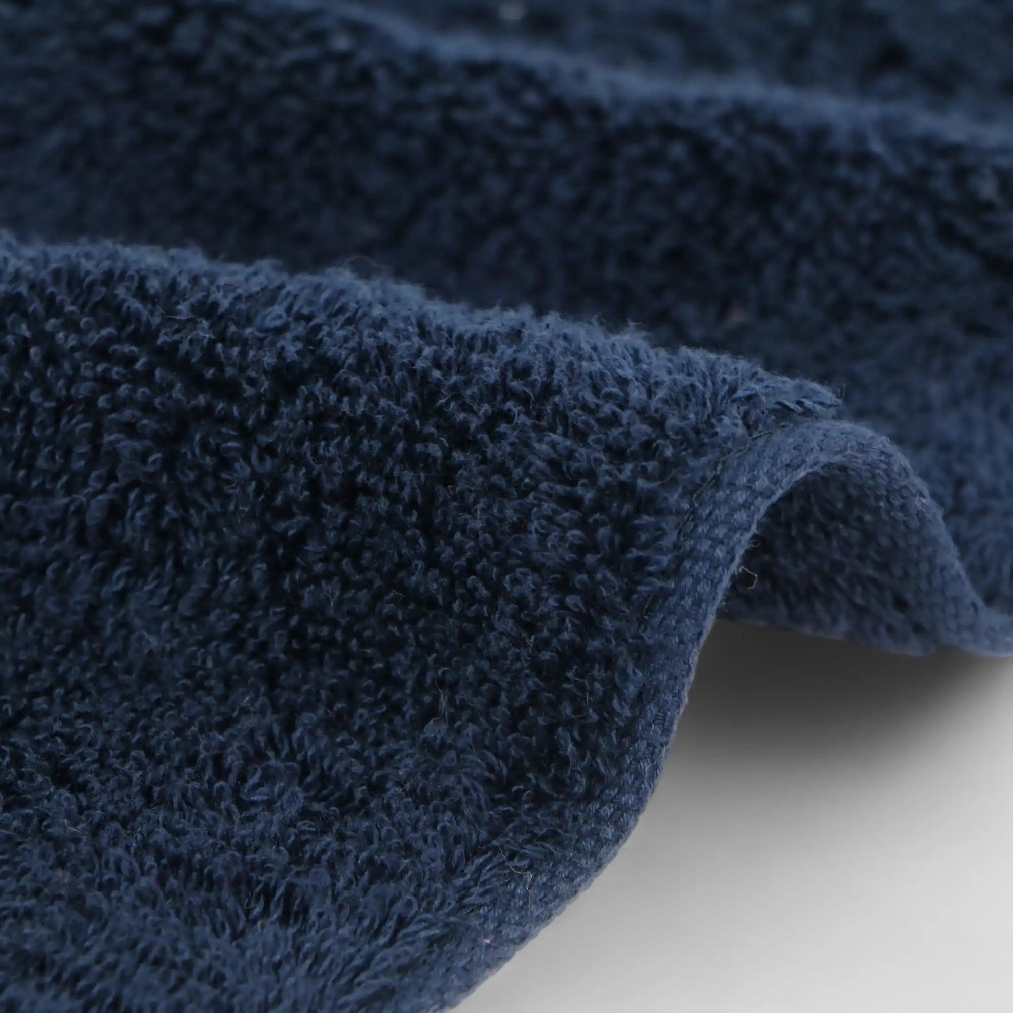 Close-up of a navy imabari towel on a light gray background