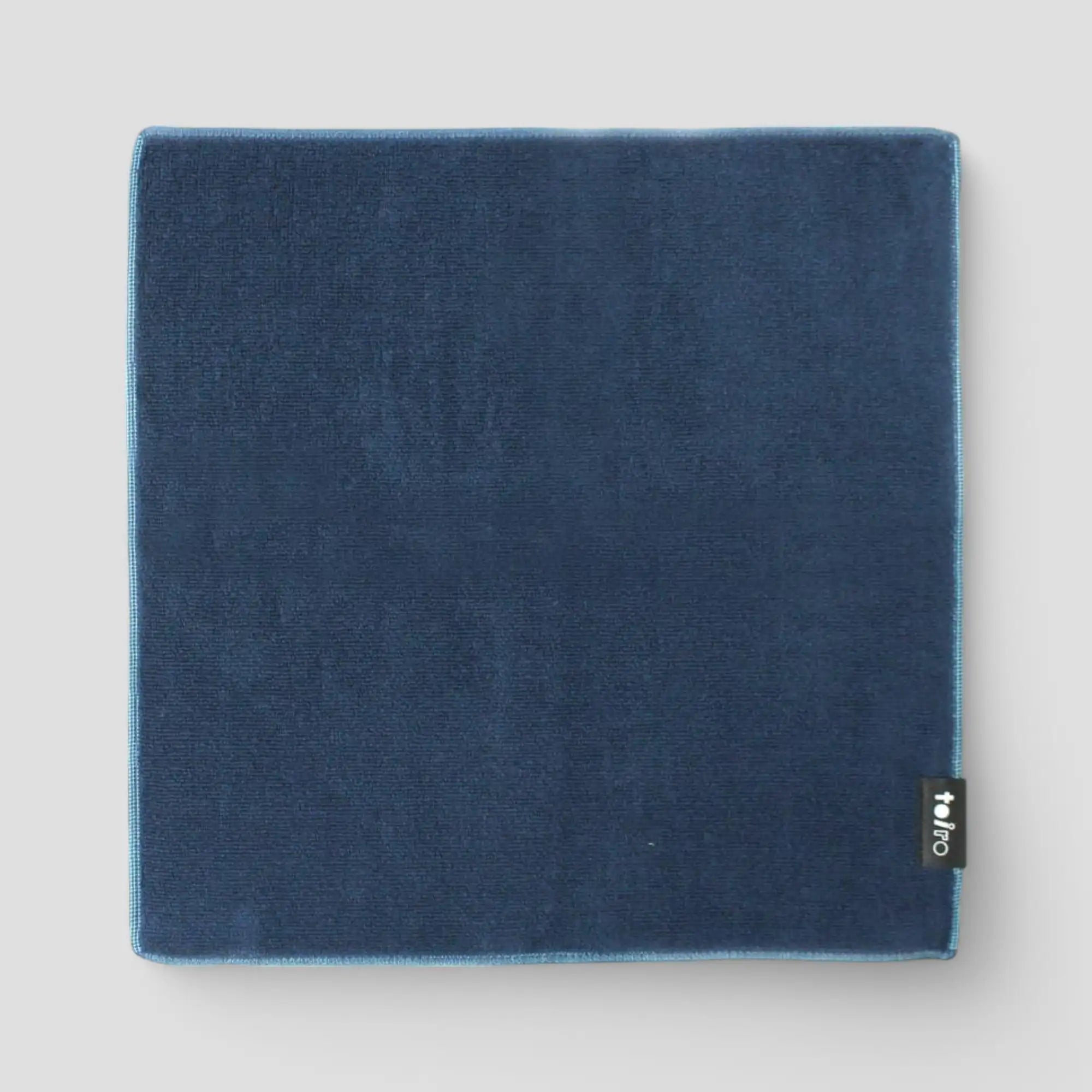 A square navy Imabari towel displayed light-gray background