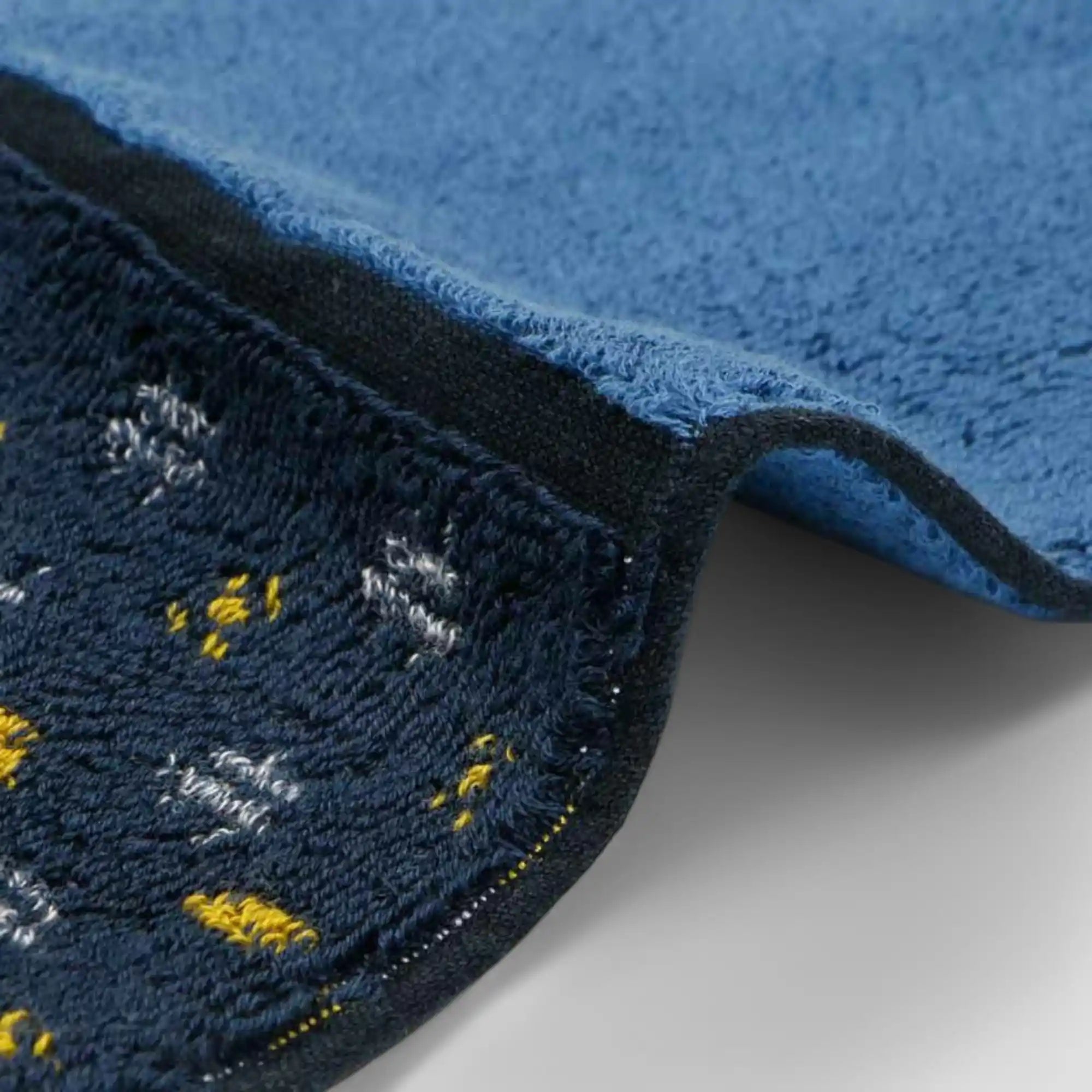 Close-up of a side of a Imabari towel in blue with yellow pattern
