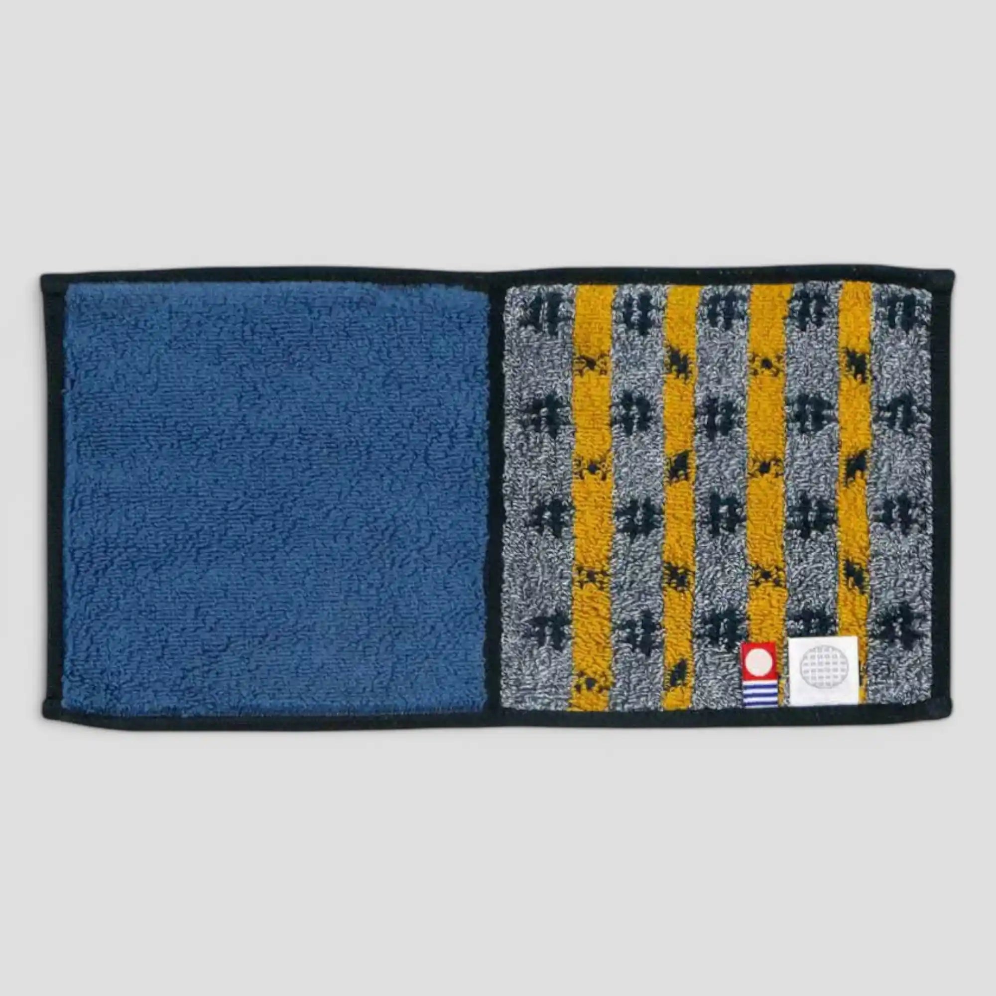 A Imabari towel in blue with yellow pattern, back side, displayed against a white background.
