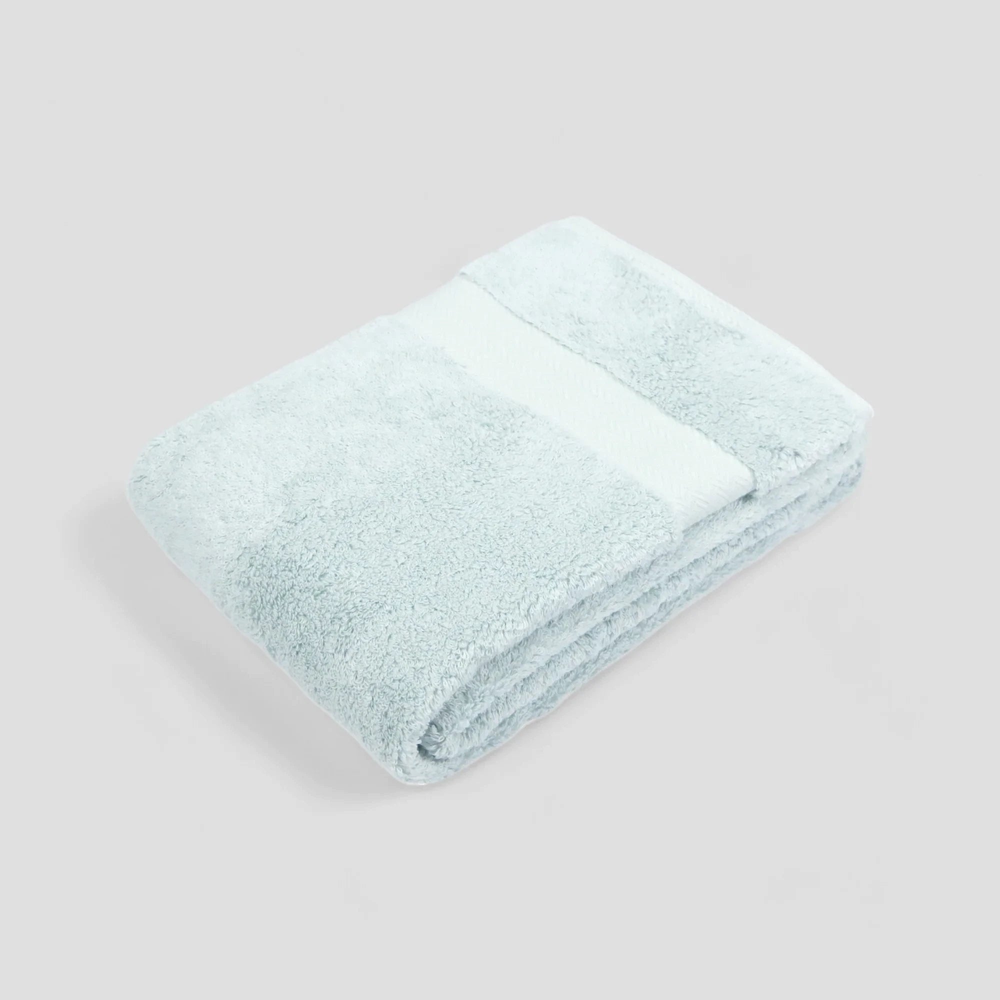 A stack of folded Imabari Towels in white, pink, and blue colors made from pima cotton.