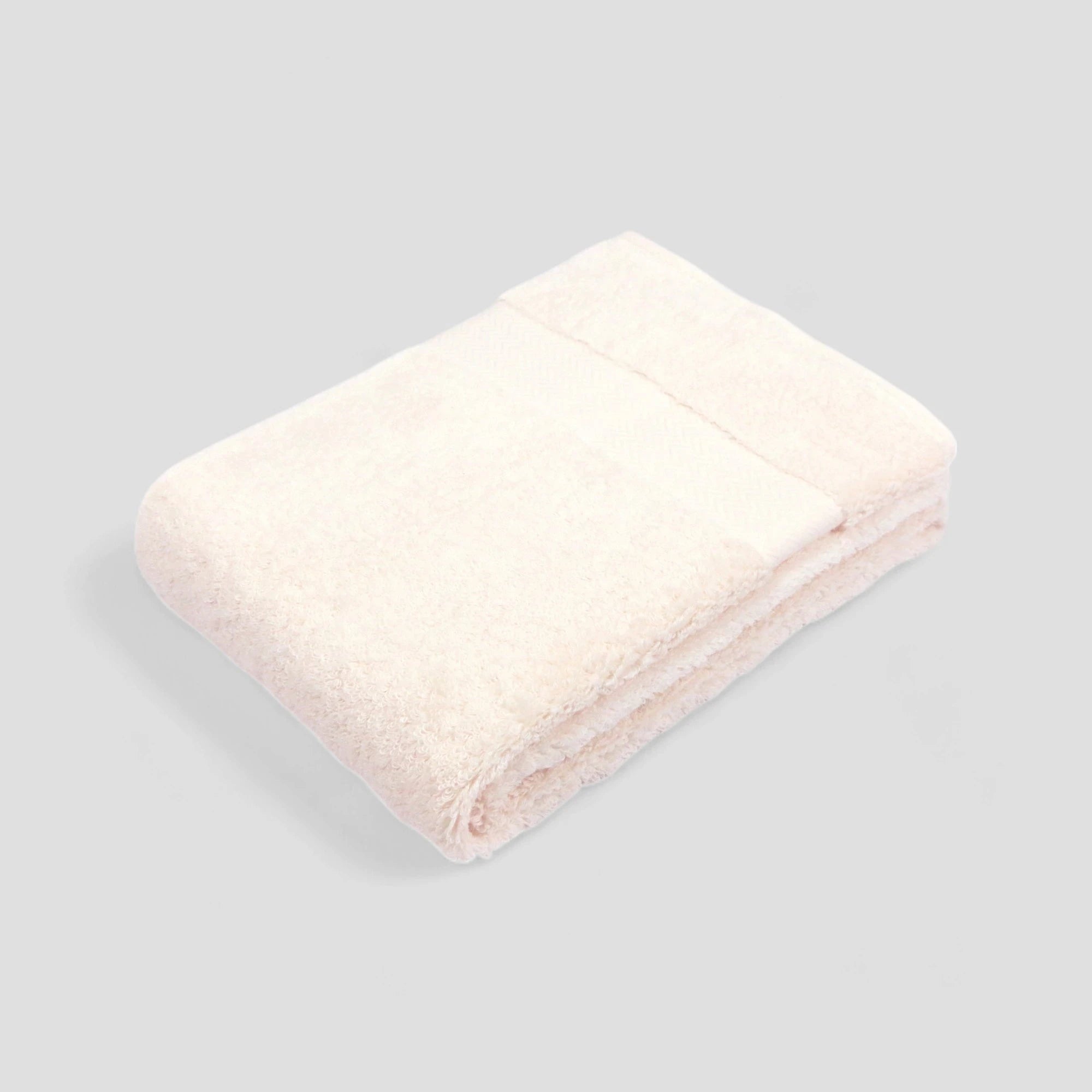 A stack of folded Imabari towels in white, pink, and blue colors made from pima cotton.