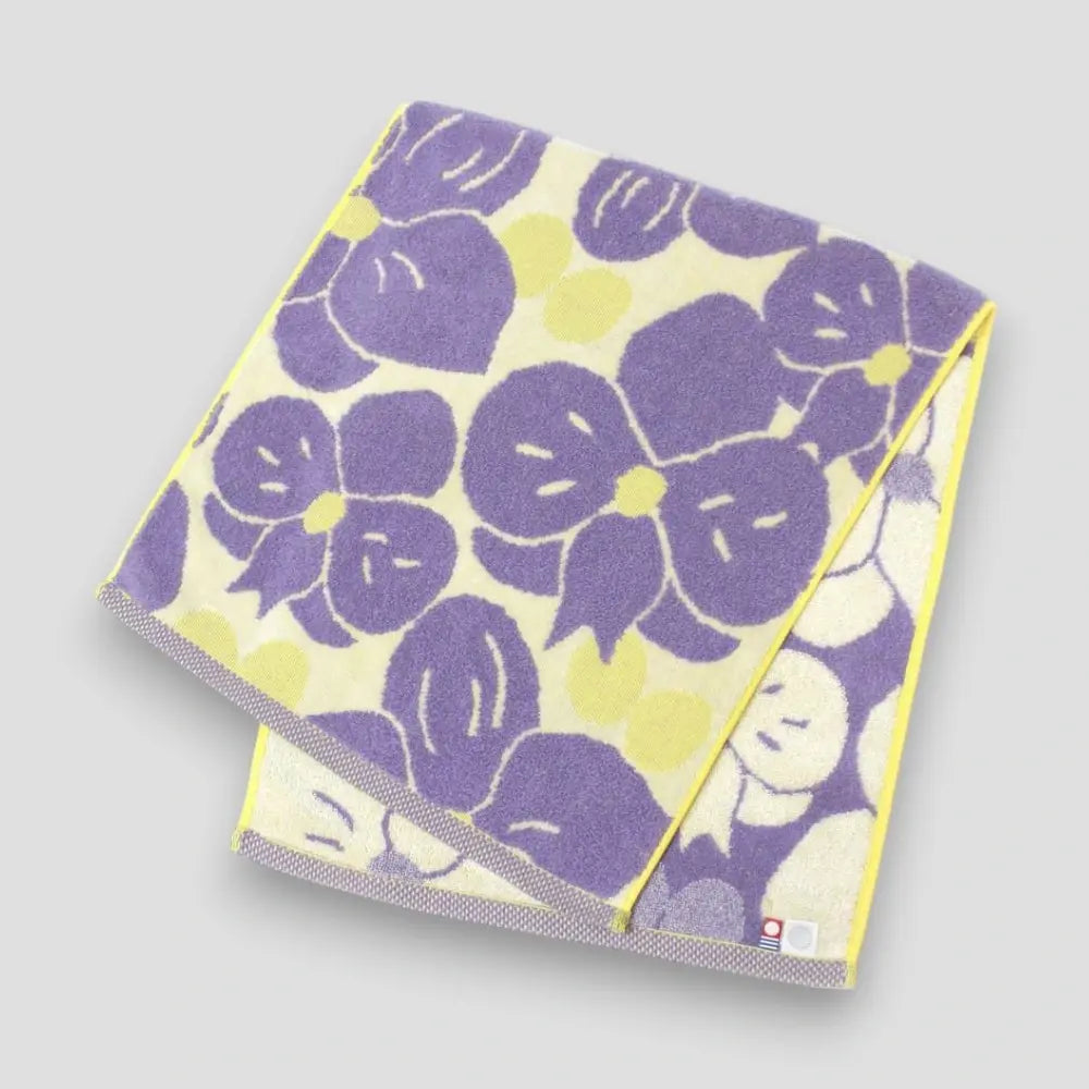 Imabari towel with purple floral pattern, showing labels of Imabati towel brand mark and IORI&