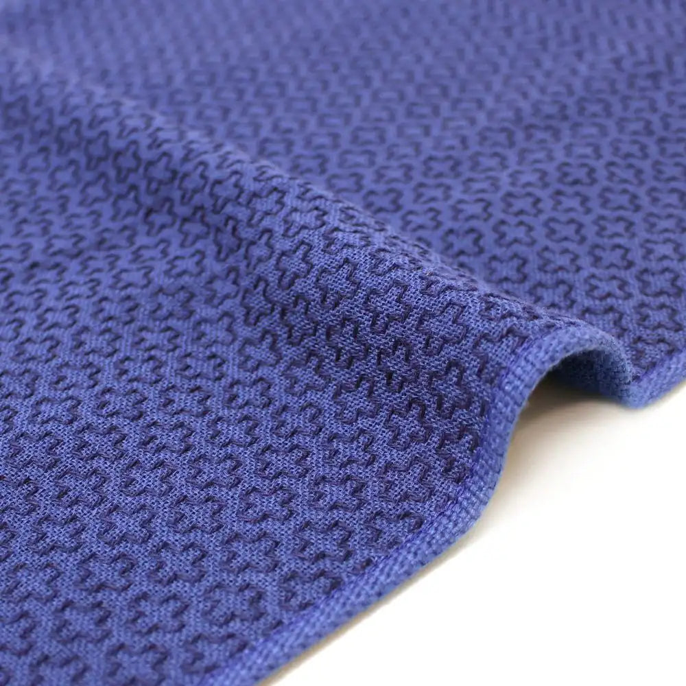 Close-up of a side of a blue Imabari towel with a geometric pattern.