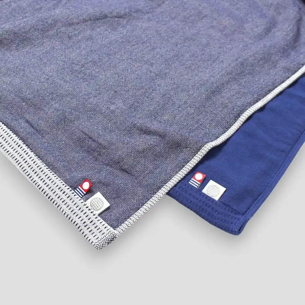 Close-up of white and blue Imabari towels on gauze side with a imabari brand logo mark.