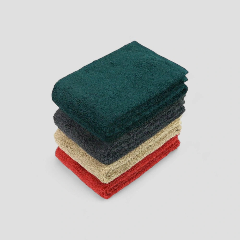 A stack of folded Imabari towels in various colors including green, beige, red, and gray, made of cotton.