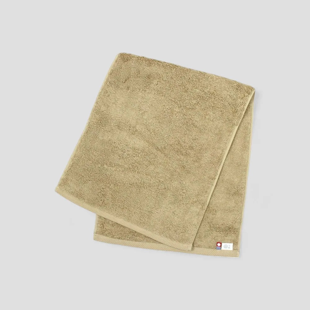 Folded beige Imabari towel showing brand labels