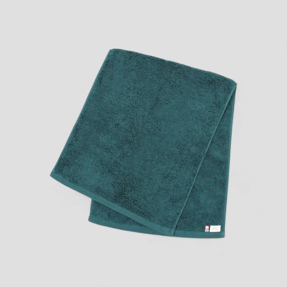 Folded green Imabari towel showing brand labels