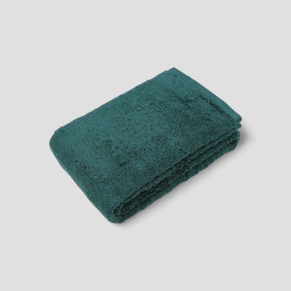 Folded green Imabari towel on the gray background