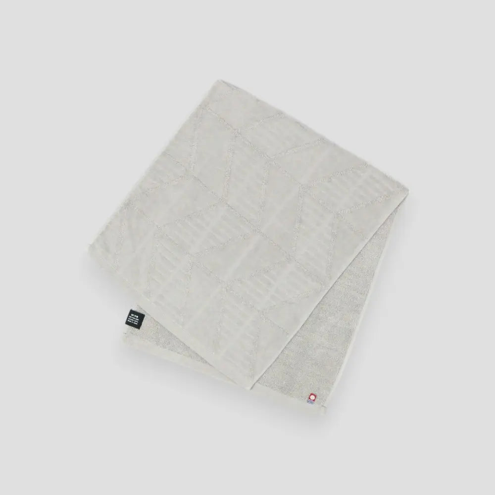A gray Imabati towel with a brand label on a light gray background