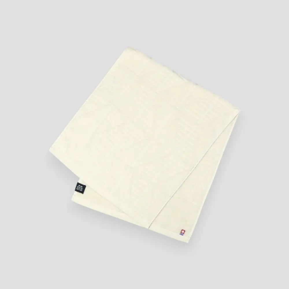 A white Imabati towel with a brand label on a light gray background