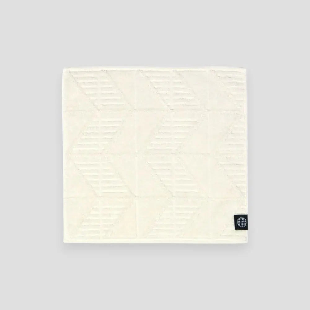 White Imabari towel with herringbone pattern on a light gray background