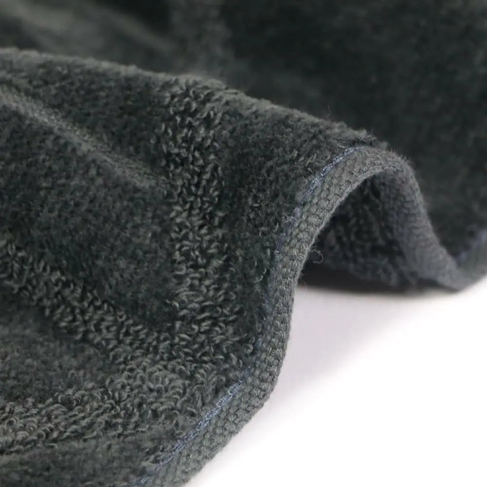 Close-up of a textured charcoal gray Imabari towel  on a light gray background