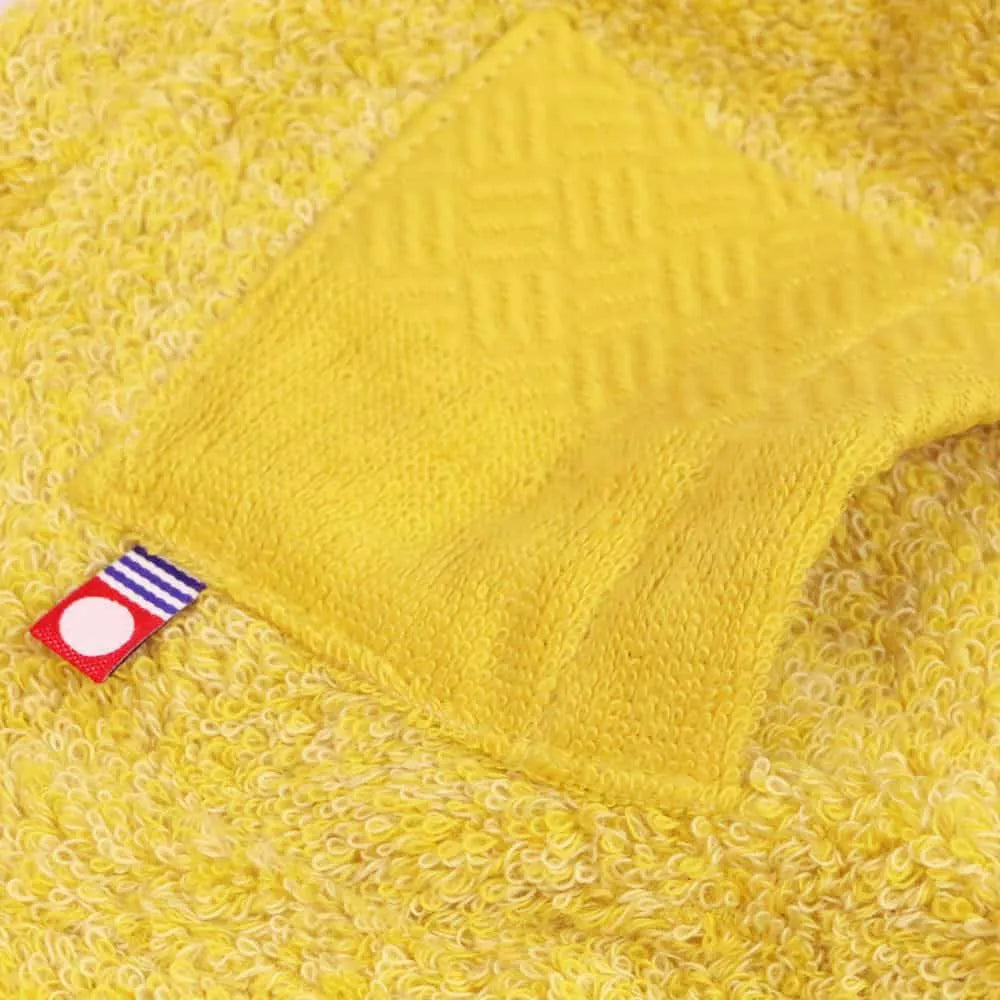 Close-up of the brand tag and pocket on the yellow sauna hat made from Imabari Towel
