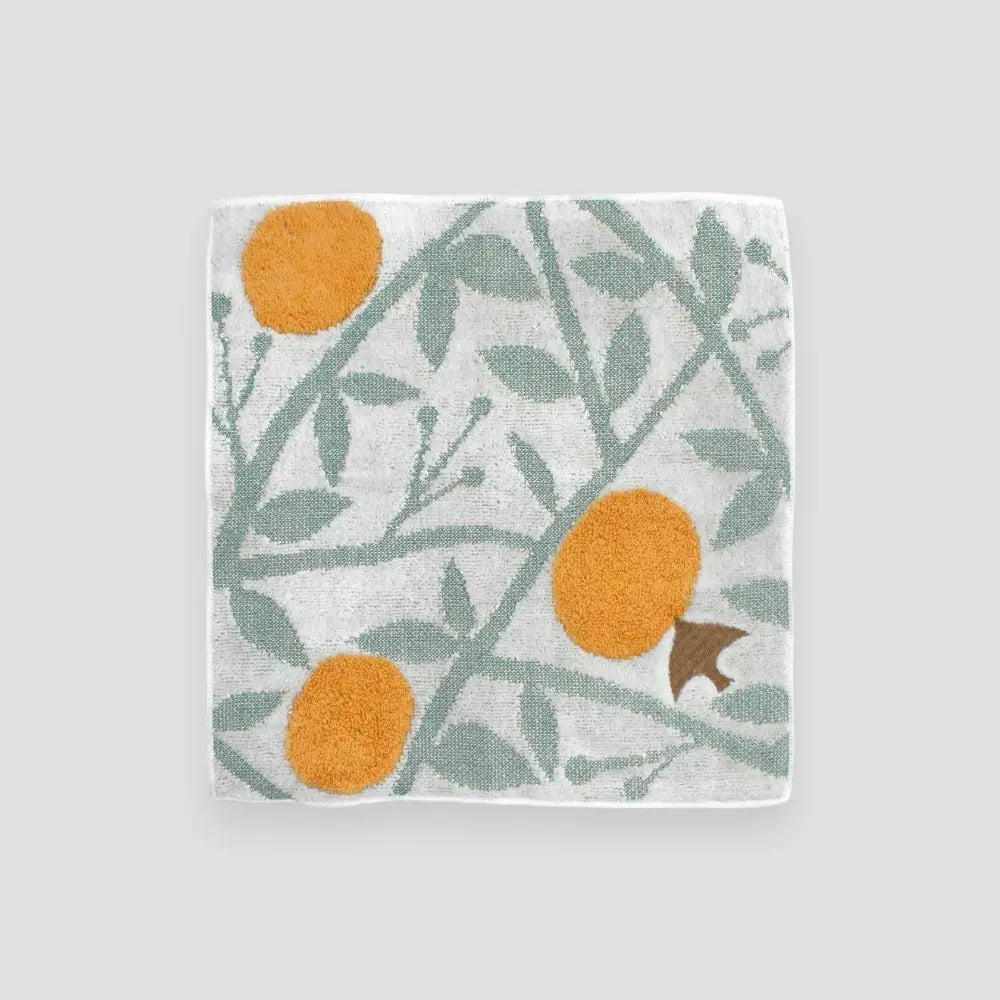 A multicolored small Imabari  towel with a bird, orange and leaf pattern 