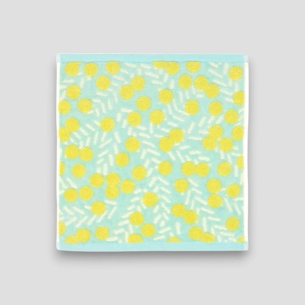 A square blue Imabari towel with yellow floral pattern