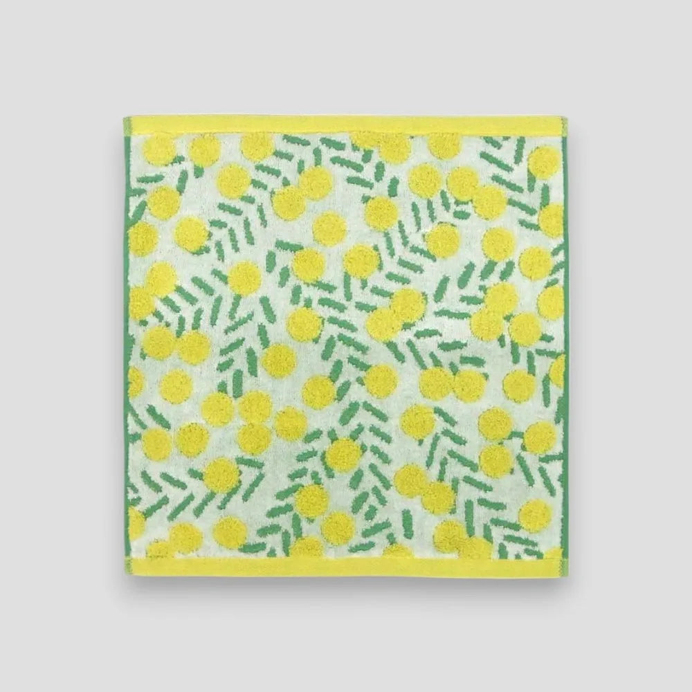 A square white Imabari towel with yellow floral pattern